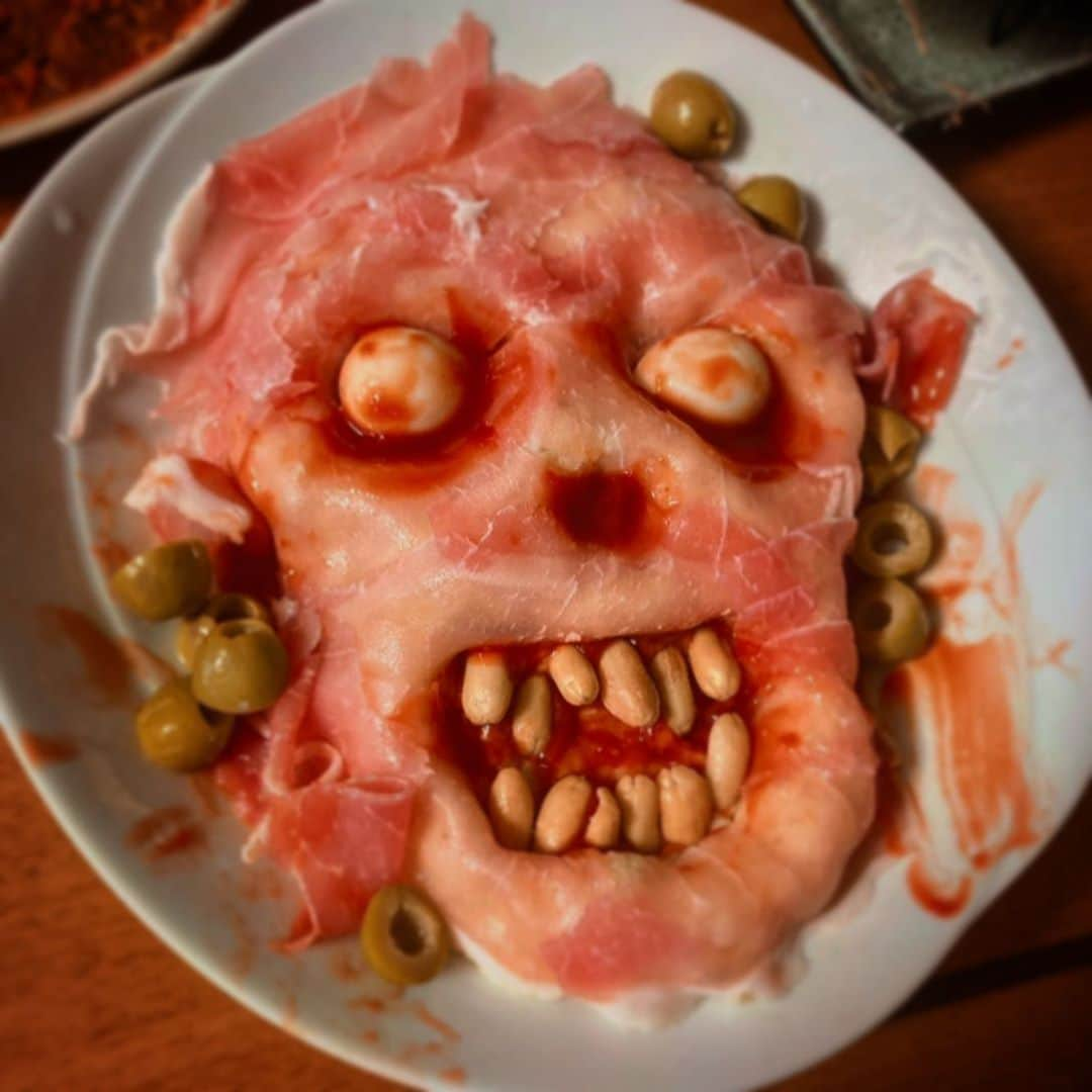 ニコラのインスタグラム：「☺︎happy halloween〜食われるのはオマエダ〜☺︎詳細編  1.暗闇より蘇りし呪いのゾンビ。 美味しいポテトサラダで形成した土台に生ハムを乗せて皮膚感を演出。歯は塩ピーナっツ、目はうずらの卵。  2.この手誰の手❓気になる手❓ チョリソーは指のシワを入れてから焼く。焼けたら先端を爪の形に削ぎ切り、至る所にケチャップを。意外とセンスが試される一品。  3.クモの巣のケーキ🕷市販のマシュマロをレンジで数秒温めて、ビヨーンと伸ばしてケーキにひっかけてゆくと蜘蛛の巣になる  4.墓 りんごとかぼちゃに彫り込みを入れオーブンで焼く。土はキーマカレー。カレーの上にりんごやかぼちゃをたたせるにかぼちゃの端材をボイルしてマッシュして使いました  5.旨味脳天 (職場の廃棄でもらったシェルマカロニ)ケチャップとマヨで味付け。もっとドロっと感が欲しかったのでマヨを減らしてチーズを入れてもいいし、ゼラチンや片栗粉で気持ち悪いプルルン感を出すのもありだったかな  6.のぞきめ 言わずとしれたのぞきめ。 職場の廃棄でもらったそうめんをいかすみソースで味付け。 瞳の部分に箱根土産の燻製うずらの卵を使ったせいで可愛らしい印象に。  7.うんこ たくさん食べて、トイレに行って、がんばるとできあがります。丁寧に扱ってね  #halloween #ハロウィン #ハロウィン料理 #不気味料理 #ハロウィンパーティ」