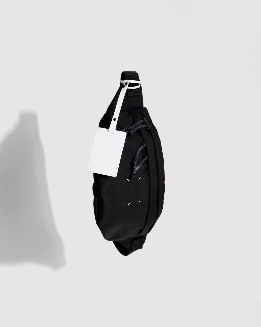 A+Sのインスタグラム：「in stock now   ■Maison Margiela 4-STITCH BUM BAG XL COLOR : BLACK SIZE : W 37㎝ ×D 11㎝ ×H 23㎝  PRICE : ¥78,000 (+TAX)  ※こちらの商品は実店舗＆お電話での通信販売のみとなります。お求めの際はお気軽にお問い合わせ下さい。  STEREOTYPEのバムバッグをサイズアップしたキャンバス製バッグです。フロントにメゾンを象徴する4本ステッチのディテールがあしらわれ、コントラストを効かせたレザータブを備えています。プルタブ付きのファスナー開閉式で、バックで調節可能なストラップが配されています。 イタリア製。   A canvas bag that is an upsized version of the STEREOTYPE bum bag. The front features four stitching details that symbolize the Maison and features contrasting leather tabs. It has a zipper closure with a pull tab and an adjustable back strap. made in Italy.  #a_and_s #MaisonMargiela #MaisonMargielaBUMBAG #MaisonMargiela4STITCHBUMBAGXL @maisonmargiela」