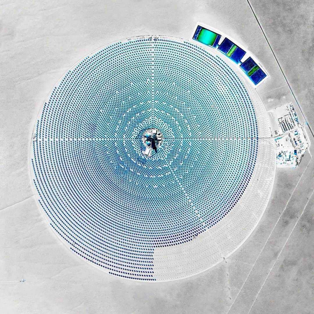 Daily Overviewさんのインスタグラム写真 - (Daily OverviewInstagram)「The Crescent Dunes Solar Energy Project near Tonopah, Nevada, uses 17,500 heliostat mirrors that collect and focus the sun’s thermal energy to heat molten salt flowing through a 540-foot (160 m) tall solar power tower. Seen here during its construction in 2015, the molten salt at its center then circulates from the tower to a storage tank, where it is used to produce steam and generate electricity. - In a recent report, the International Energy Agency (IEA) declared solar to be the cheapest means of generating electricity worldwide, saying the cost per megawatt to build a solar plant is now cheaper than any fossil fuel facility. - Created by @overview, source imagery: @maxartechnologies」10月26日 2時14分 - dailyoverview