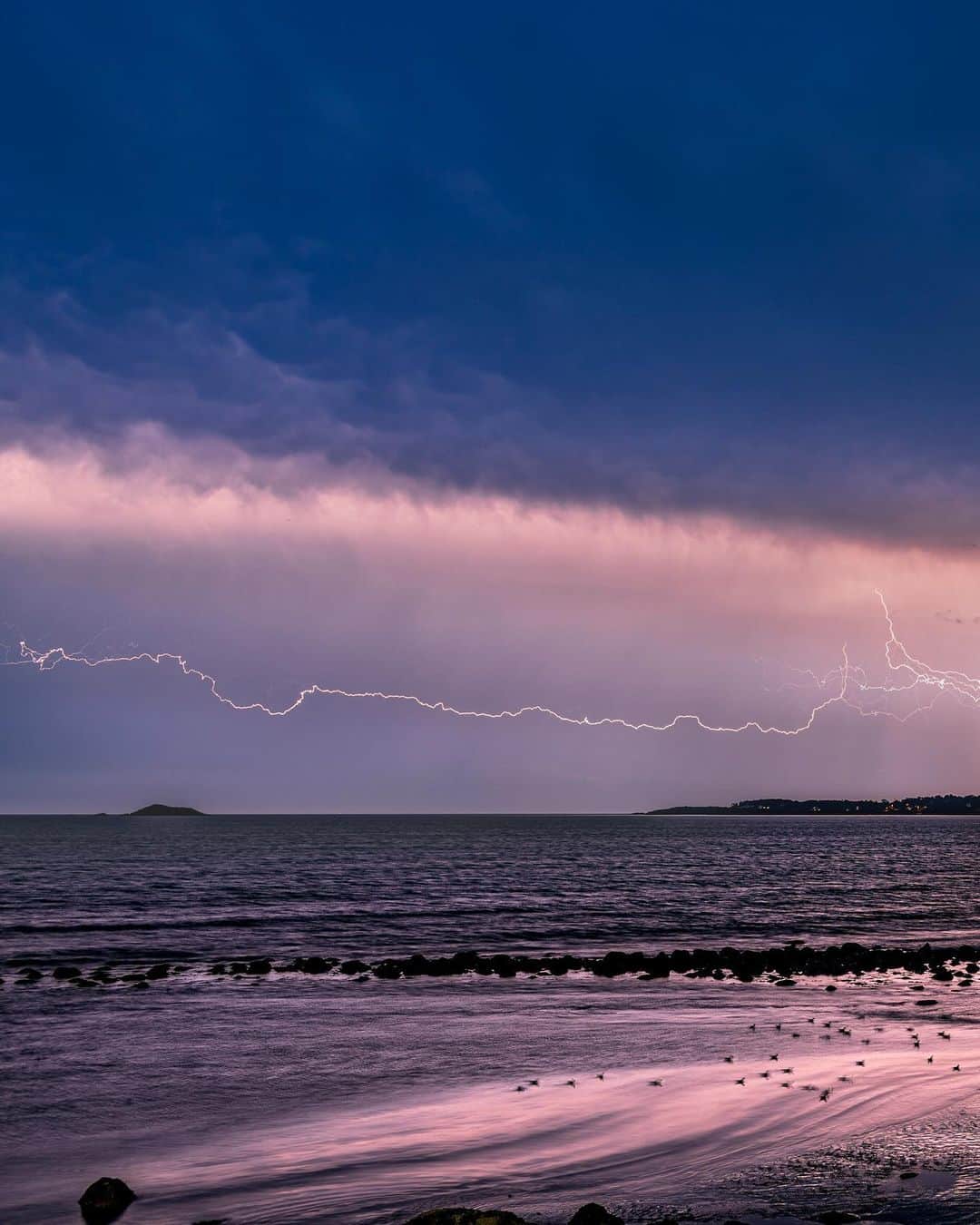 のインスタグラム：「Photo by @babaktafreshi / Slowly swipe to see the entire image. A late August storm races through New England in this four-second exposure. In my neighborhood, north of Boston, spectacular lightning appeared over the Atlantic and the towns  of Lynn and Nahant. This horizontal flash was surprising, a  cloud-to-cloud type—when a negatively charged cloud finds a positively charged cloud. Explore more of the world at night with me @babaktafreshi. #boston #ocean #storm #nightphotography」