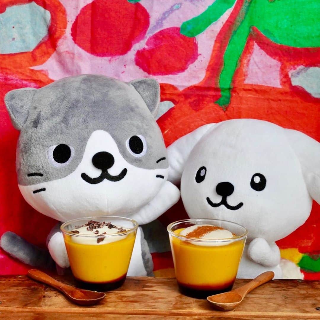 のインスタグラム：「【ダス犬とつくろ♪ヘルシー料理】 豆乳とかぼちゃのヘルシープリン♪ おうちでハロウィンパーティーをしよう！  ●かぼちゃプリン　150ccカップ4個分  A：プリン生地 無調整豆乳(アーモンドミルクなどでもOK) 400cc メープルシロップ　50g かぼちゃフレーク 40g 粉寒天　小さじ1/2 葛粉(または片栗粉) 5g 水　大さじ1  B：カラメルソース てんさい糖　50g 水　大さじ１ 熱湯　大さじ１  C：豆腐クリーム 木綿豆腐　100g メープルシロップ　15g 塩　少々 ココナッツオイル　小さじ2  シナモンやカカオニブ　少々  1.Cを作る。木綿豆腐は一晩水切りをしておく。そのほかの材料と一緒に滑らかになるまでブレンダーにかけ冷蔵庫で冷やす。  2.Bを作る。小鍋にてんさい糖と水を入れ、弱火にかける。鍋をよく回しながら沸騰させ続け、鍋の縁から煙が少し上がりほんのり焦げた匂いがしたら火を止めてすぐ熱湯を加える。激しく沸騰するので火傷にご注意を。鍋をよく回してソースが滑らかになったら、プリン型の底に流し入れる。  3.Aを作る。鍋に粉寒天、葛粉、水を入れて溶かし、かぼちゃフレークを混ぜる。豆乳を少しずつ加えダマにならないように混ぜていく。最後にメープルシロップを加えて、中火にかける。ゴムベラで焦げ付かないように鍋の底をよく混ぜ続けて、もったりとした感触になったら弱火にし、1分程加熱する。  4.火を止め、すぐにプリンカップに流し入れる。流し入れたプリンカップを台の上で軽くトントンとたたき、空気を抜き表面を平らにする。粗熱が取れたらラップをして冷蔵庫で5時間以上冷やし固める。  5.プリンの上に冷やしておいた豆腐クリームをかけて、お好みでシナモンやカカオニブをトッピングする。  ＊MEMO＊ 卵、乳製品を使わないプリンです。冷やし固めるだけなので作るのもカンタン。容器は耐熱のガラスカップやココットを使ってください。  レシピ監修 @iina_veganfoodcreator」