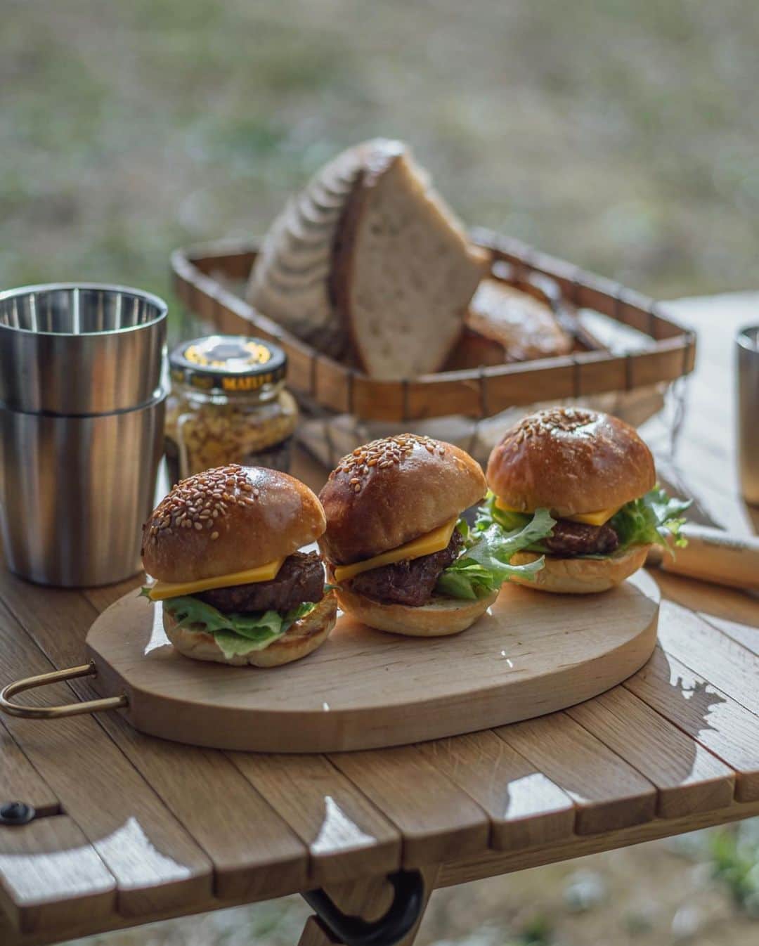 Nanaのインスタグラム：「day camp  ヒーコメンバーで、それぞれ担当を決めてのデイキャンプ。私はビーフシチューを。 限られた時間で作れて、冬でも美味しく食べられるものって何だろうと悩んでビーフシチューにしてみたのだけど、数時間も煮込むわけにはいかないし、当日使うお肉から旨みが出るとは限らないし、1時間ほどでは味が決まらないと思って、事前にデミグラスを仕込んで。あとは適当にマデイラワインとトマトピューレをドボドボと入れて。 煮込み時間が限られているので、短時間でも柔らかくなりやすい頬肉を使って。 ついでに、ミニバンズが手に入ったので、ボスの高級なお肉をもらって、デミグラスを絡めて、ゆみちゃんのマスタードを借りて、スライダーを作った🙆🏻‍♀️  ポットラック的なのも良い◎  光がダメすぎるので写真は諦めてたけど記録的にスナップ。 スライダーを載せたカッティングボードは枯白さんの個展で。四角いのも気に入っているけど、キャンプにはこの軽さありがたい！メープルの杢が美しい✨」