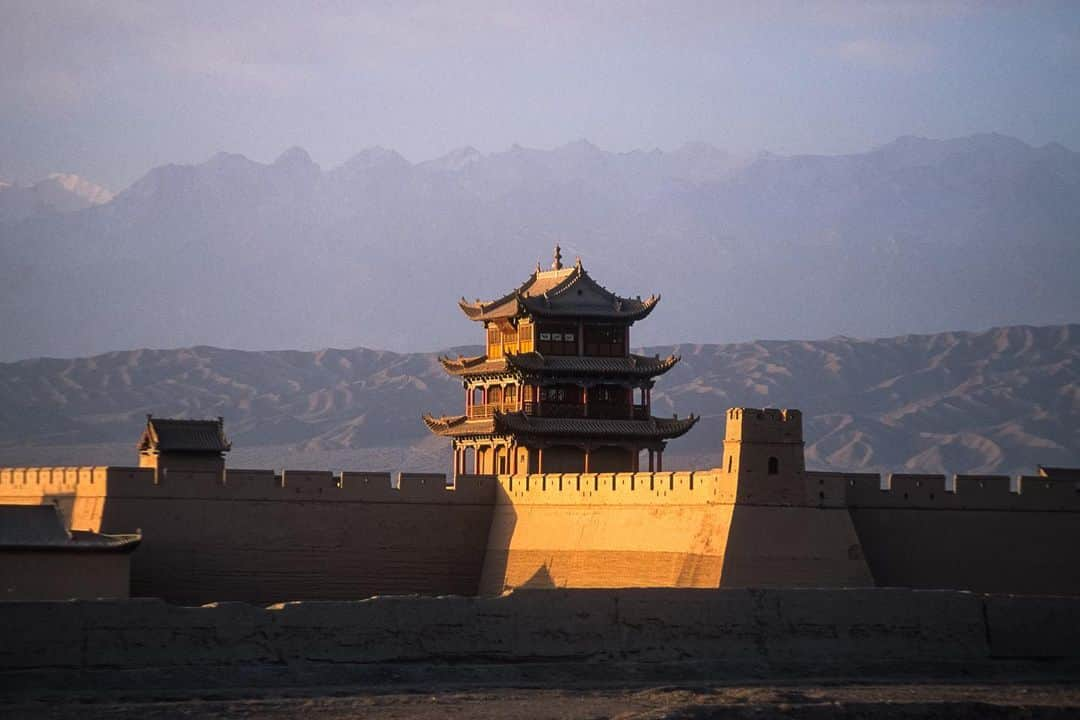 Michael Yamashitaさんのインスタグラム写真 - (Michael YamashitaInstagram)「Early morning light turns turns earthen walls into glowing reflectors: Jiayuguan (Jiayu Pass) marks the western edge of the Ming Dynasty portion of the Great Wall of China. The  fortress was built to protect the western frontier of the Chinese empire and played a key role as the entry point to China along the ancient Silk Road.  If this looks familiar, it’s because it was also used as a location in Disney’s big-budget live-action remake of Mulan, where the final battle takes place.  Many of China's most photogrenic landscapes, like this one, were showcased in the film. #jiayu #jiayuguan #jiayuguangreatwall #greatwallofchina #greatwall #silkroad #gansu #mulan @thesilkroadjourney」11月21日 0時42分 - yamashitaphoto