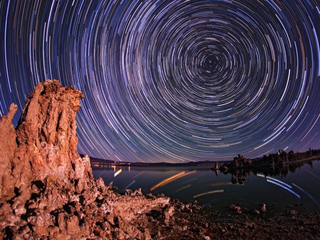 National Geographic Travelさんのインスタグラム写真 - (National Geographic TravelInstagram)「Photo by @babaktafreshi / On a perfectly clear and calm moonlit night over Mono Lake in California, this time-exposure image reveals the Earth's rotation in about one hour. The Earth's rotation turns the sky above the fixed camera, creating star trails around the north celestial pole, marked by the North Star, Polaris. The scattered image of the stars on the water shows more colors, with colder old orange-red stars and hotter young blue giants. Mono Lake is famous for its stunning exposed tufa towers of limestone formed by the precipitation of carbonate minerals in water.  Explore more of the world at night photography @babaktafreshi. #twanight #startrails #astrophotography」11月22日 0時37分 - natgeotravel