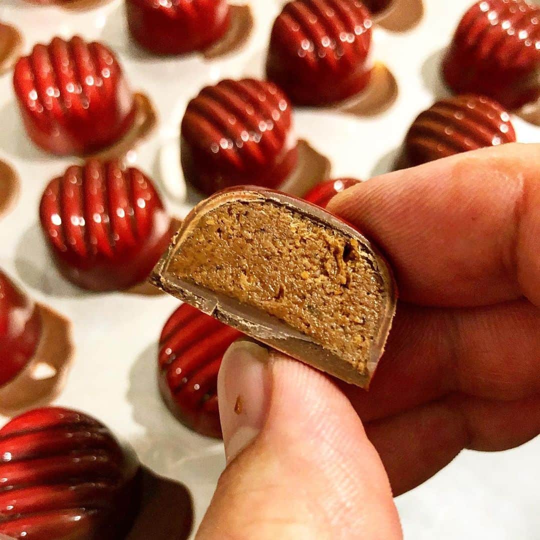 eguchikazuakiのインスタグラム：「昨晩、これ↑食べ過ぎちゃった。﻿ ﻿ 見てよこれ﻿ ﻿ イタリアピエモンテの高級ベーゼルナッツのプラリネと﻿ デリーモの香ばしいミルクチョコ合わせたの。﻿ もうこんなことされたらどうするよ‼️﻿ ﻿ よくボンボンショコラって私も小さい頃食べたあの﻿ お酒わっちゃーってやつをイメージしますよね。﻿ お菓子屋で働くようになって知ったんですが﻿ 小さい一口サイズをボンボンショコラって言うらしいですよ😊﻿ だからこれもボンボンショコラ‼️﻿ お酒は入っていません、ザクザクギャリギャリ美味い、美味い、美味い🔥 ﻿ 前紹介したピスタチオのプラリネと同じシリーズで﻿ これはヘーゼルナッツ﻿ あとはピスタチオ﻿ それ以外にもフィリピン産のココナッツのプラリネ🥥﻿ プラリネシリーズはめちゃくちゃ美味い﻿ 今年最大の自己満足ヒットです﻿ ﻿ 早く売りに出したいなー﻿ 皆さん楽しみにしていてくださいね﻿ チョコレートは熟成させます👋🏻  #delimmo #デリーモ #プラリネ #チョコレート#ボンボンショコラ #マルコナ #ヘーゼルナッツ #ココナッツ #ミルクチョコレート #アラシエンヌ #パティシエ #ショコラティエ #新作 #10種類以上 #江口和明 #eguchikazuaki #チョコレート大好き #テンション高め」