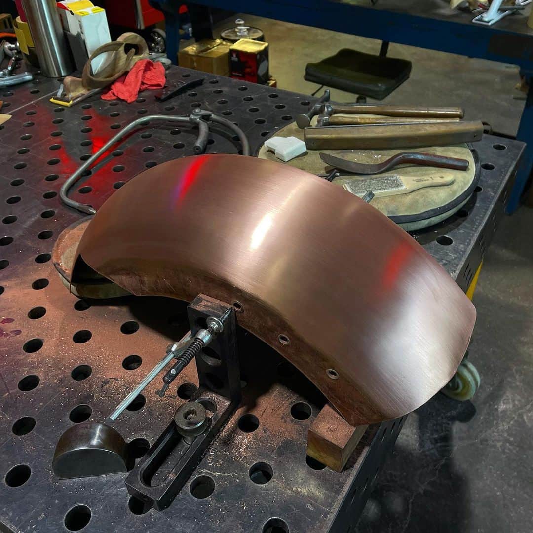 ウエストコーストチョッパーズのインスタグラム：「........... Getting there.  Not perfect but better than when I started this morning😘.  I usually have to cut myself off at some point because I could just keep going and going. Still need to metal finish the sides.  Finish the belt cut out,  Do the wire edge work. Make semi hidden front mount,  And hand make a tail light. Other than that it’s almost a handmade copper rear fender😛  #jessejames」