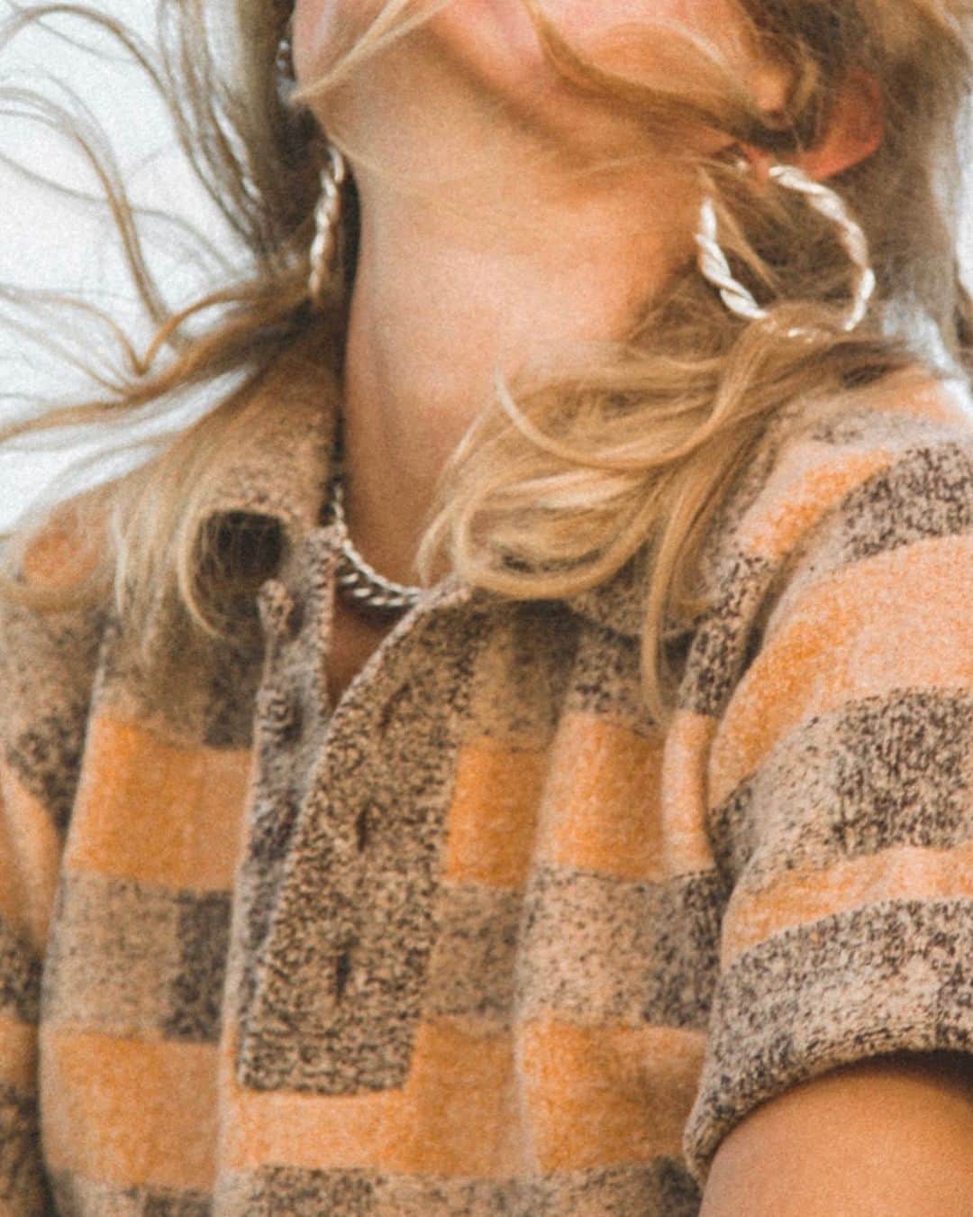ダニジョーのインスタグラム：「Hair in the wind, feet in the sand 🐚 Shop the Naomi hoops and Checkerboard Polo at the link in bio 〰️」