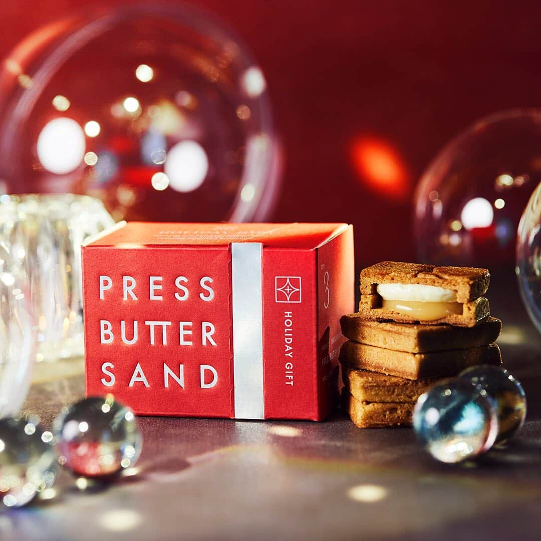 PRESS BUTTER SANDさんのインスタグラム写真 - (PRESS BUTTER SANDInstagram)「12/1(火) より「バターサンド ホリデーギフト」が期間限定で登場。 本日より10組20名様にプレゼントが当たる、Instagramキャンペーンスタート。  ホリデー気分を高めてくれる真っ赤なパッケージが印象的な「バターサンド ホリデーギフト」は、中に定番のバターサンド3個が詰まったプチギフトです。キラリと光るロゴと、リボンを巻き付けたようなシルバーのジッパーラインが特徴。ジッパーを剥がすと個包装のバターサンドが現れるデザインは、子どもの頃に体験したような、プレゼントを開ける瞬間のワクワクした気持ちを思い出させてくれます。  日頃からお世話になっている方やご友人へのホリデーギフトとしてぜひご利用ください。  ▼商品について詳しくはこちら https://buttersand.com/news/holidaysbox2020  🎁 #バターサンドのホリデーギフト キャンペーン🎁 11/30(月)までInstagramのストーリーで #バターサンドのホリデーギフト キャンペーン第1弾を開催中です。 ストーリー投稿いただいた方の中から選考で10組20名様に「バターサンド ホリデーギフト」をプレゼント✨  ▶︎詳しくは、@pressbuttersand プロフィール > ハイライト [キャンペーン] をチェック  みなさまのご参加をお待ちしております。  ------------- .. . #プレスバターサンド #pressbuttersand #バターサンド #ホリデーギフト #ホリデー #クリスマスプレゼント #キャラメル #クッキー #バター #手土産 #お土産 #おみやげ #プレゼント #贈り物 #ギフト #プチギフト #お菓子 #スイーツ ﻿ #ご褒美スイーツ﻿ #おうちスイーツ #スイーツ好き ﻿ #スイーツ部 #おうちカフェ #ティータイム #今日のおやつ #期間限定 #冬スイーツ」11月24日 14時47分 - pressbuttersand