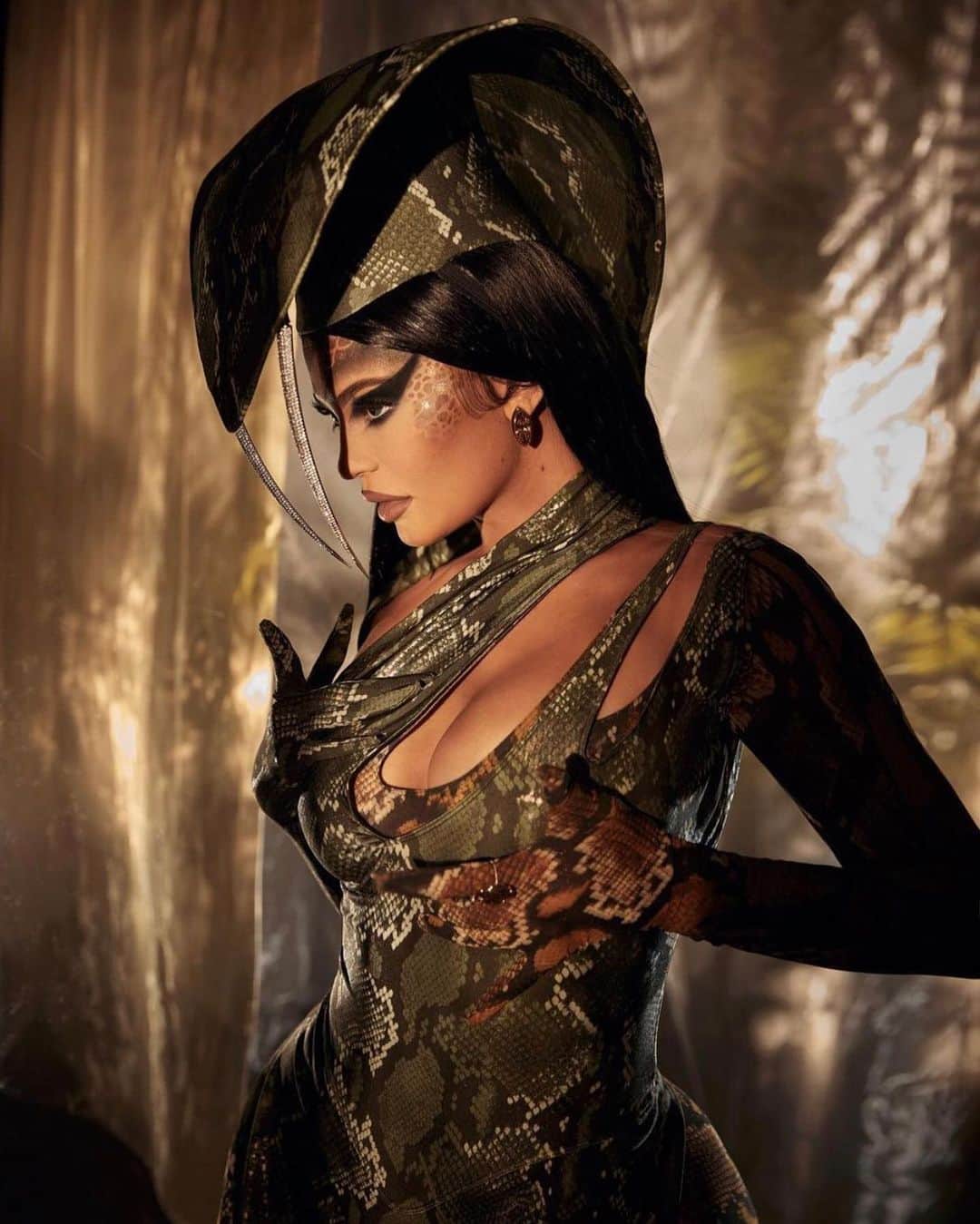 ミュグレーのインスタグラム：「@kyliejenner wears custom MUGLER by @cadwallader for Halloween 2020. A holographic python printed bodysuit and a matching hat with crystal encrusted metal fangs. - - Stylist @jilljacobsstudio  Photographer @gregswalesart  Headpiece by @stephenjonesmillinery for MUGLER  #mugler」