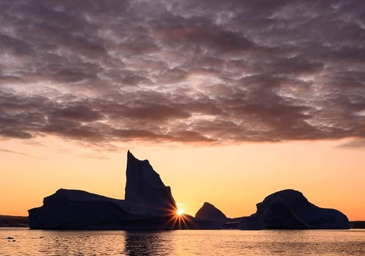 National Geographic Travelさんのインスタグラム写真 - (National Geographic TravelInstagram)「Photo by @daisygilardini / An incredible sunrise appears while cruising among giant icebergs in Scoresby Sund along Greenland's east coast. Creating a starburst can add an interesting, eye-catching element to your photography. It can be achieved both at night and during the day. Simply point the lens toward a bright source of light (the sun or a streetlight will do) using a wide-angle lens at a small aperture (f/18 or f/22). The number of spikes depends on the number and shape of aperture blades. Lenses with eight aperture blades will produce a star with eight spikes, while lenses with an odd number of aperture blades will double the spikes.  Follow me @DaisyGilardini for more images and stories behind the scenes. #iceberg #starburst #greenland #scoresbysund #landscapephotography」11月1日 16時40分 - natgeotravel