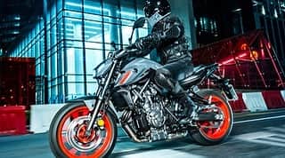 ヤマハ バイクさんのインスタグラム写真 - (ヤマハ バイクInstagram)「ヤマハ発動機株式会社は、「クロスプレーン・コンセプト」※に基づき開発した水冷・4ストローク・DOHC・2気筒・4バルブ・689cm3・270度クランクエンジンを搭載するロードスポーツ「MT-07 ABS」をマイナーチェンジし、欧州向けに発売します。また、2021年春以降に日本での発売を予定しています。   今回の「MT-07 ABS」は、「Accessible MT with a Fitter Body」をコンセプトに開発しました。幅広いライダーから支持を得ているCP2（クロスプレーン・コンセプトの2気筒）エンジンの特性を継承しながら、新しいデザインを採用し、さらに総合的なパフォーマンスを向上させています。   新たな特徴は、1）EU5適合CP2エンジン、2）より快適でアップライトなライディングポジション、3）バイファンクションLEDヘッドランプ（Hi-Lo一体）とLEDポジションランプ、フラッシャーランプ、4）次世代MTシリーズへ進化したスタイリングなどです。 ※ クロスプレーン・コンセプトは、慣性トルクが少なく、燃焼室のみで生み出される燃焼トルクだけを効率良く引き出す設計  #YAMAHAが美しい #MT07 #yamahamt07 #yamahamtseries #newmotorcycle #darksideofjapan   1）EU5適合CP2エンジン  クロスプレーン・コンセプトに基づいた689cm3・水冷・2気筒・270度クランクの最新CP2エンジンを搭載。80.0mm x 68.6mmのボアストローク、11.5:1の圧縮比から、最高出力54.0kW/8,750r/min、最大トルク67.0N・m/6,500 r/minを発揮します。  EU5適合化を図りながらエアダクト、排気系仕様変更（新型の「2into1エキパイ・マフラー一体型」）、ECU仕様変更、FIセッティング最適化などを織り込むことでスロットル微開の低速域での、リニアなレスポンス特性に磨きをかけました。  その他、耐摩耗性に優れたバルブシート採用（排気側）、ミッションのドッグ角変更で再加速時のダイレクト感向上（2速・3速）、触媒位置変更、 O2センサー位置変更などを行っています。  これらによって従来モデル比でトルクの出力特性は滑らかになっており、優れた加速特性を実現しています。  2）より快適でアップライトなライディングポジション  燃料タンクカバー周りのデザインを一新しました。燃料タンクカバー周りを構成するパーツを従来の9個から8個へ減らし、フレームカバーをアルミダイキャストから樹脂製に変更。ニーグリップ部の形状と立体感は、スポーツ走行時のホールド感に貢献します。  また、新たにアルミ製テーパーハンドルを採用しました。左右幅を32ｍｍ広く、ハンドル高を12mm高く設定し、幅広い体格のライダーにフィットし、ゆったりとした乗車姿勢を確保しています。  3）バイファンクションLEDヘッドランプ（Hi-Lo一体）とLEDポジションランプ、フラッシャーランプ  鮮明な照射範囲と配光を備え、ロービームとハイビームを一体型としたバイファンクションLEDヘッドランプを採用しました。ロービームは、照射エリアとエリア外の境界の明暗差が少なく穏やかなので、境界付近での良好な視認性を得られます。このヘッドランプはコントロールユニットをタンデムシート下に設置しており、よりコンパクトなフロントフェイスに貢献しています。  また、フラッシャーランプとポジションランプには、「MT-07」初のLEDを採用しました。ポジションランプは左右に独立しており、コンパクトなヘッドランプ周りによって一目で「MT-07」と分かるデザインに仕上げました。  4）次世代MTシリーズへ進化したスタイリング  2013年の初代以降2度目のアップデートで、第3世代MTシリーズとしてスタイリングも進化しました。  ヘッドランプなど新しいデザインのコンポーネントを織り込みながら、最低限の構造体を魅力的な造形でまとめつつ、ヘッドランプ周辺の各パーツ類をエンジン中心方向に大胆に寄せ、MTらしい引き締まった“塊”のイメージを再現しています。加えて、LEDポジションランプにイニシャル「Y」モチーフを取り込み第3世代MTシリーズの象徴としています。  またサイドビューでは、MTシリーズのトルク&パワー感を視覚的に強く訴えかけるために、エアフローの動きを取り込んだスタイリングとしています。一方、トップビューでは、空気を取り込み張り出したイメージのタンクカバーとライダーの自由な動きをサポートするスリムなシートエリアの対比で大きな抑揚を作り、前に突き進むパワーを表現しています。」11月4日 11時19分 - yamaha_bike