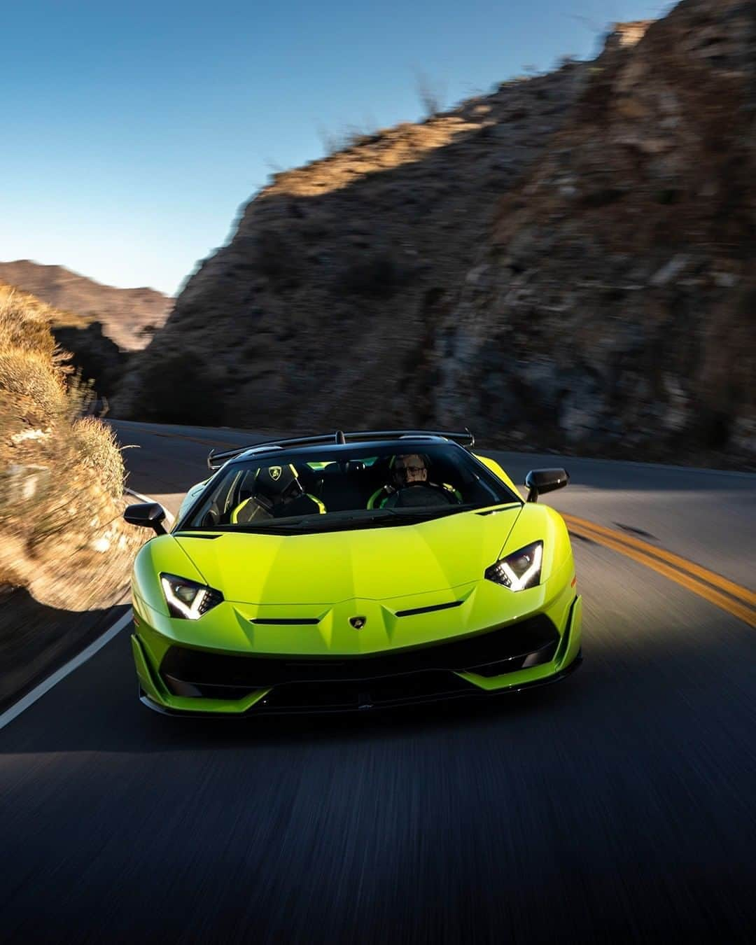 ランボルギーニさんのインスタグラム写真 - (ランボルギーニInstagram)「If the road could talk, it would ask our Aventador SVJ Roadster not to stop anymore.  Can you guess the color of this iconic model? Is it Verde Ithaca or Verde Scandal?   #Lamborghini #AventadorSVJRoadster #GuessTheColor」11月5日 3時12分 - lamborghini