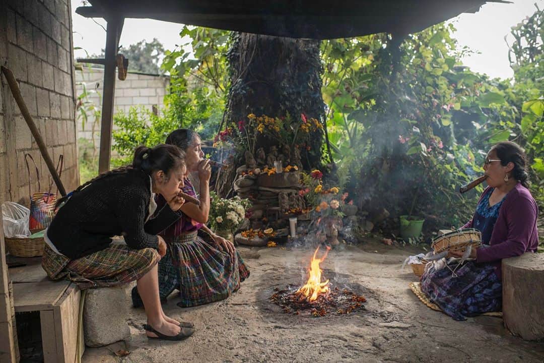 National Geographic Creativeさんのインスタグラム写真 - (National Geographic CreativeInstagram)「Photo by @daniele_volpe / Maria Saturnina Us Alvarez (center), accompanied by her daughters Sara Tuyuc Us (left) and Rosario Tuyuc Us, leads a Maya ceremony at her home to honor the loved ones that passed away during Day of the Dead celebrations. The family lost four members during the Guatemalan Civil War. Because of the COVID-19 pandemic they were unable to travel to visit their loved ones’ grave sites. They feel that the pandemic doesn't change how they connect with the deceased since they are used to practicing Mayan spirituality at home.  In Guatemala, and in other countries of the region, the "Day of the Dead" celebrations are deeply felt. The tradition consists of visiting the tombs of loved ones during November 1 and 2. Generally, families bring food and drinks as a way to "share" that with the relatives that died. The tradition is a happy occasion, accompanied by music and surrounded by food street vendors. This year, due to COVID-19, Guatemalan authorities decided to restrict access to the cemeteries to avoid crowds.  After the 36-year-long Guatemalan Civil War (1960-96), according to the UN, Guatemala counts more than 200,000 victims and 45,000 missing people including civilians. After the peace accords, human rights organizations started an effort to find the remains of the "desaparecidos." Chimaltenango was one of the departments of the country hardest hit by the state repression and has well-known atrocities that happened in San Juan Comalapa.  In 2003, forensic anthropologists started digging in a plot of land where an army camp once stood. They found the remains of 220 people in several mass graves. People that were kidnapped by the Guatemalan Army, executed and buried inside that army camp. After DNA analysis, 172 of them are still unidentified.  Taken on assignment for @natgeo and @icrc.」11月8日 23時27分 - natgeointhefield