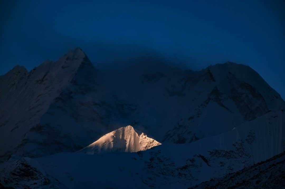 ナショナルジオグラフィックさんのインスタグラム写真 - (ナショナルジオグラフィックInstagram)「Photo by Keith Ladzinski @ladzinski / A kiss of light illuminates an isolated peak at the foot of Mount Everest on a stormy morning. This mountain is over 7,000 meters (23,000m) tall, dwarfed by the towering giants of the valley.」11月9日 18時33分 - natgeo