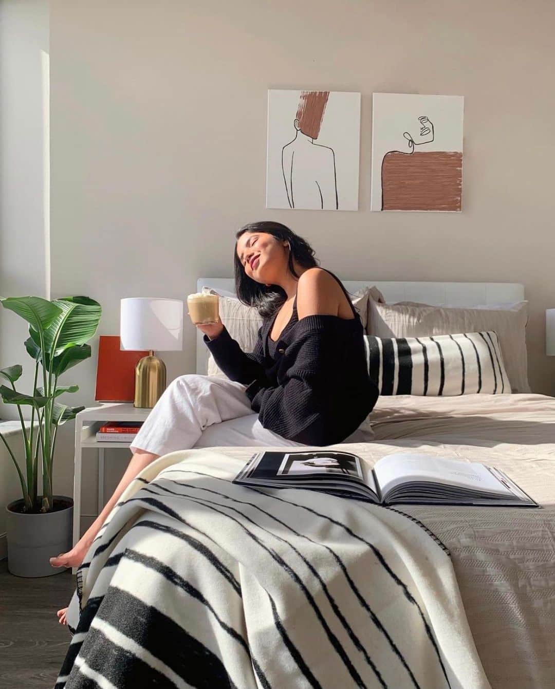 ケネスコールのインスタグラム：「Today feels like a new dawn…@natashatyagii enjoys a warm moment as hope beds in with our faux wool throw and breakfast pillow. #FreshStart #ComfortZone #FallStyle  When you shop at KennethCole.com, we’ll donate to The New York Public Library in support of The Harry Belafonte Black Liberation Speaker Series. Info link in bio.」