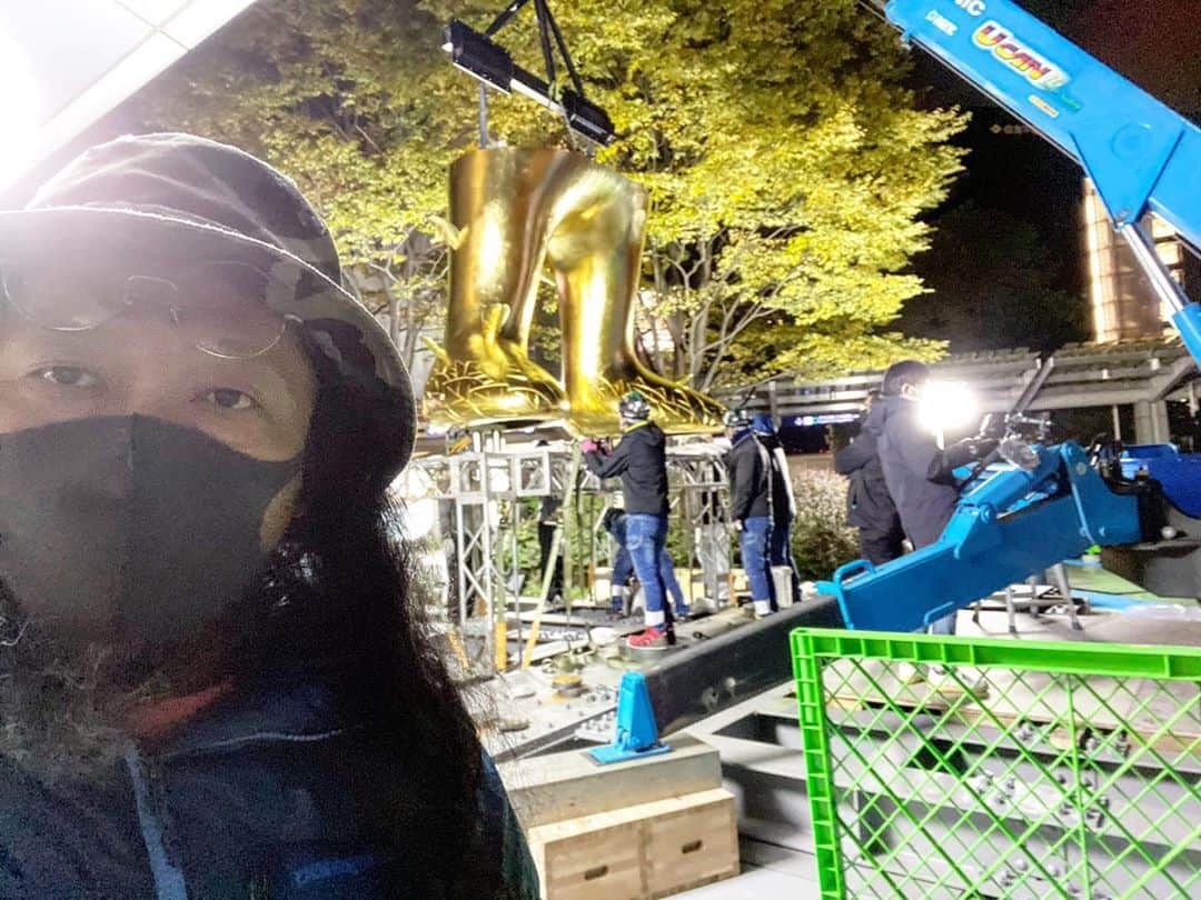 村上隆さんのインスタグラム写真 - (村上隆Instagram)「I am sure everyone has been living through the 2020 pandemic with complex feelings. I, for one, having gone to the precipice of my company’s collapse for a moment, found it almost unbearable and wished to die many, many times. For a few months, I didn’t want to wake up in the morning and hoped I would just die in sleep. But since I live in my studio, by the time I wake up, the company is already in motion for the day; I had no choice but to turn the switch on every morning and, with no time to wallow in suicidal thoughts, immersed myself in solving the problems.  On November 26, my 10-meter-high Flower Parent and Child sculpture (Haha Bangla Manus) will be revealed in the courtyard of Roppongi Hills in Tokyo. I had to make the decision not to halt the project and to continue paying the fabricator in the midst of our near-bankruptcy drama, and it was a tremendous decision to make—I thought my innards would come out of my mouth. We did manage to avoid bankruptcy and the project is steadily moving forward, but that was a truly painful decision to make. For the past two weeks or so, the preparations for the installation have finally been underway. The Mori Building staff, the installers, and the shippers are on site, while the fabricators from the Walla Walla Foundry participate remotely from Washington State, with Kaikai Kiki’s Exhibition Director, Shin Kitahara, representing me on the ground. But sever wind and rain, as well as the pandemic preventing the fabrication team from joining in person, have made the process tremendously difficult.  My artworks generally feature happy characters full of smiles, so most people mistakingly assume both my personality and our worksite to be also cheerful and happy. But in order to create a dream, we have to constantly work side by side with vomit-inducing agony. I sincerely hope that this work will be installed safely and without any accidents. photo: @mosomota  translation: @tabi_the_fat」11月10日 22時31分 - takashipom