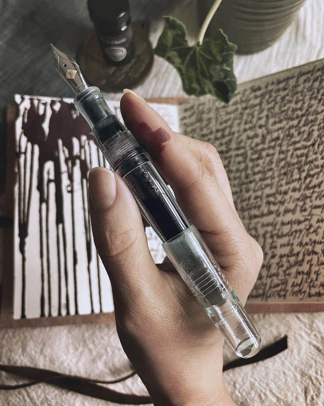 Catharine Mi-Sookさんのインスタグラム写真 - (Catharine Mi-SookInstagram)「Magic in duality and juxtaposed wonder. Complexity of being and living simply. Hopeful, melancholy and joyful all layered in one moment, all equally real. A new ink bottle arrived and I subsequently emptied the pen from its old ink contents. An ultrasonic triple cleaning and flush, new ink poured, only to splotch and splatter it all over blank pages, my fingers, underneath fingernails, and seeped onto previously filled pages and scribblings. Oops. A juxtaposition of a composed mess. I like it. As the ink drips and stains through unintended pages, so my heart etches and leaks through unexpected cracks. Movement and fluidity, stillness and calm. Magic and wonder and duality, sun and moon and stars. Thank goodness for it all. . . . . . Black Cherry ink in a newly cleaned P66 Antique Glass Pen @franklinchristoph (like cherry cola in a glass bottle). Journal made by me with all credit and thanks to the @pegandawl IGTV Bookbinding Tutorials (fave tutorials ever). . . . . . #memoirs #journaling #writinglife #franklinchristoph #fountainpens #fountainpenink #fountainpenaddict #pegandawl #handmadejournal #quaratinebookbindingclub #bookbinding #artjournaling #artjournalpages #creativejournaling #inkyfingers #inksplatter #autumnmood #penmenship #journalinspiration #creativespace #thedailywriting #stationerylove」11月13日 4時03分 - catharinemisook