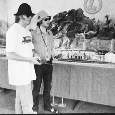 Beckのインスタグラム：「Here’s a picture of me and Neil Young wearing bucket hats and sandals playing with his beloved Lionel train set. Happy 75th buddy—sending lots of love to you and the family!! @neilyoungarchives  Photo taken by @charliegrosss」