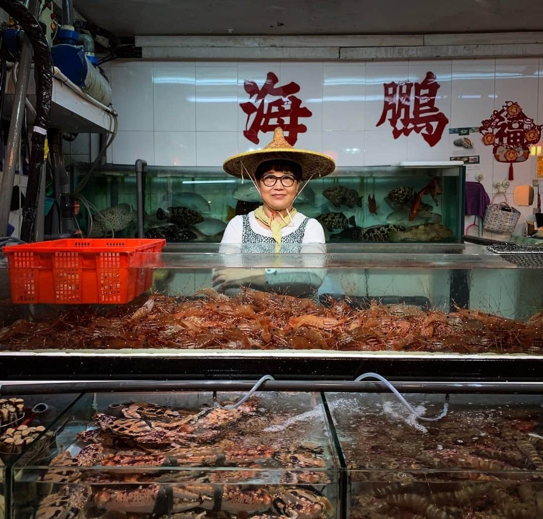 National Geographic Travelさんのインスタグラム写真 - (National Geographic TravelInstagram)「Photo by Luján Agusti @lujanag / Eunice Li stands in her fish shop at a trade fair in Hong Kong. In some countries an open-air food market is called a wet market. The name comes from the routine of wetting and cleaning the floors with water. Wet markets usually have butcher and fish shops, unlike dry markets that sell products like electronics and textiles. Although these markets have been heavily criticized, especially since the beginning of the coronavirus pandemic, live animals are not necessarily sold. The markets are characteristic of Hong Kong, where there is a crossing of Eastern and Western cultures.  Follow me at @lujanag to learn more about my work.」11月13日 20時38分 - natgeotravel