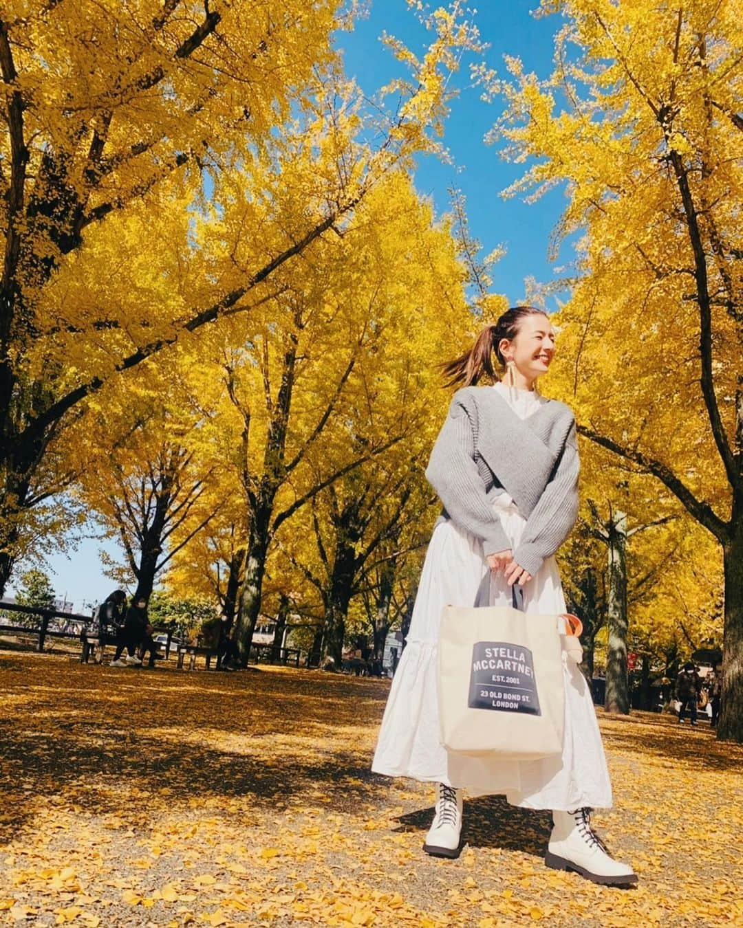 スザンヌさんのインスタグラム写真 - (スザンヌInstagram)「銀杏コーデ💛　　﻿ ﻿ 真っ黄色のお洋服着ていくか悩んだけど、﻿ 白ワンピ×届いたばかりのばってん﻿ グレーニット♡﻿ @serenececool の﻿ レースアップブーツで秋コーデして行ったんだ🧶この日の格好とってもすきだった！﻿ ﻿ 熊本県庁前には#ルフィ像 がいるんだよ♡同じポーズで🙏🙏🙏﻿ ﻿ ニット　@un3d_official ﻿ ワンピース　@ati________21 ﻿ バック　　　@stellamccartney ﻿ ピアス　　　@yumi__meow ﻿ ブーツ　　　@serenececool ﻿ ﻿ 最後は落ち葉を散らそうとしてくれるさきちゃんと楽しそうなわたしの﻿ #臨場感　溢れる1枚。すき。」11月13日 12時44分 - suzanneeee1028