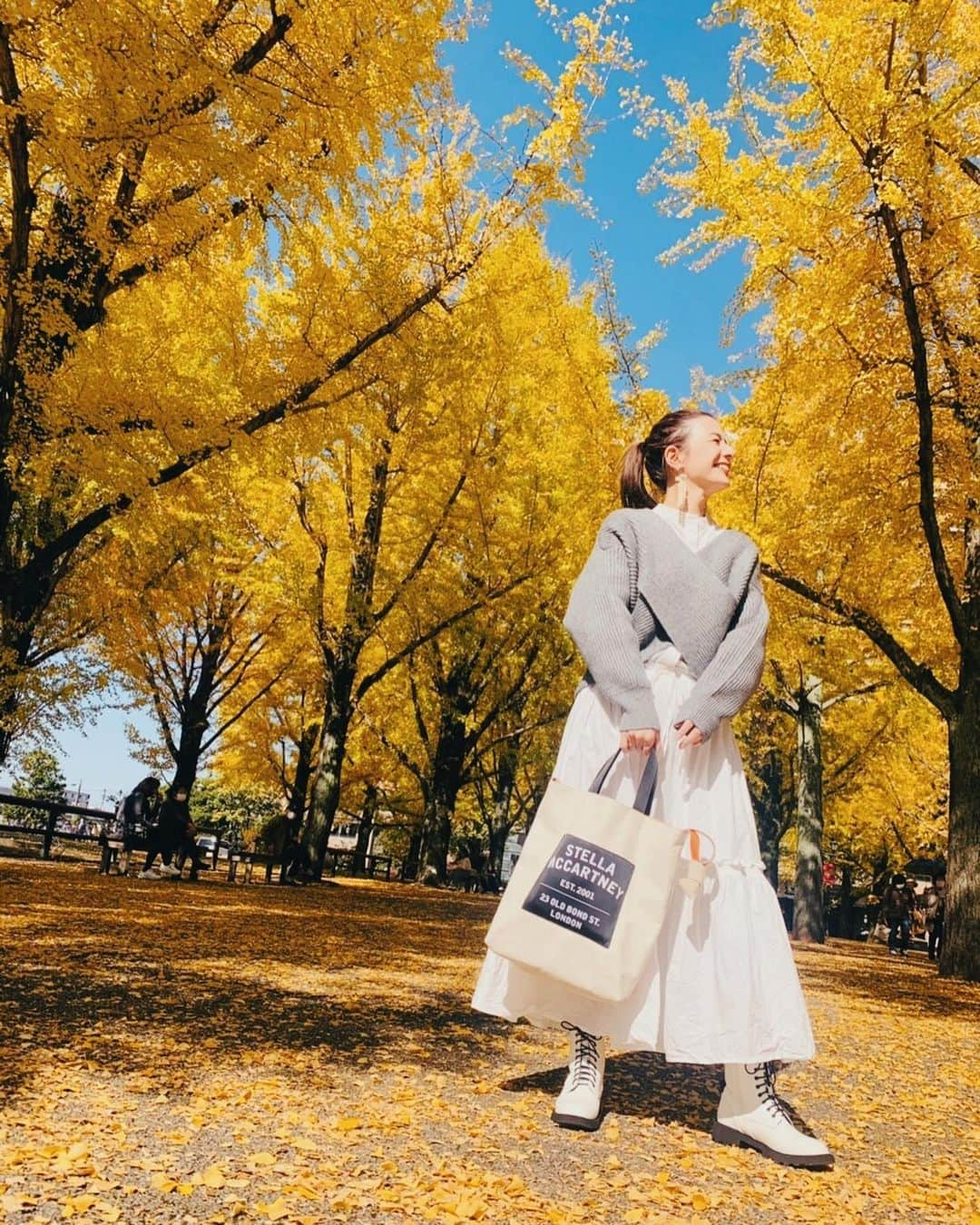 スザンヌさんのインスタグラム写真 - (スザンヌInstagram)「銀杏コーデ💛　　﻿ ﻿ 真っ黄色のお洋服着ていくか悩んだけど、﻿ 白ワンピ×届いたばかりのばってん﻿ グレーニット♡﻿ @serenececool の﻿ レースアップブーツで秋コーデして行ったんだ🧶この日の格好とってもすきだった！﻿ ﻿ 熊本県庁前には#ルフィ像 がいるんだよ♡同じポーズで🙏🙏🙏﻿ ﻿ ニット　@un3d_official ﻿ ワンピース　@ati________21 ﻿ バック　　　@stellamccartney ﻿ ピアス　　　@yumi__meow ﻿ ブーツ　　　@serenececool ﻿ ﻿ 最後は落ち葉を散らそうとしてくれるさきちゃんと楽しそうなわたしの﻿ #臨場感　溢れる1枚。すき。」11月13日 12時44分 - suzanneeee1028