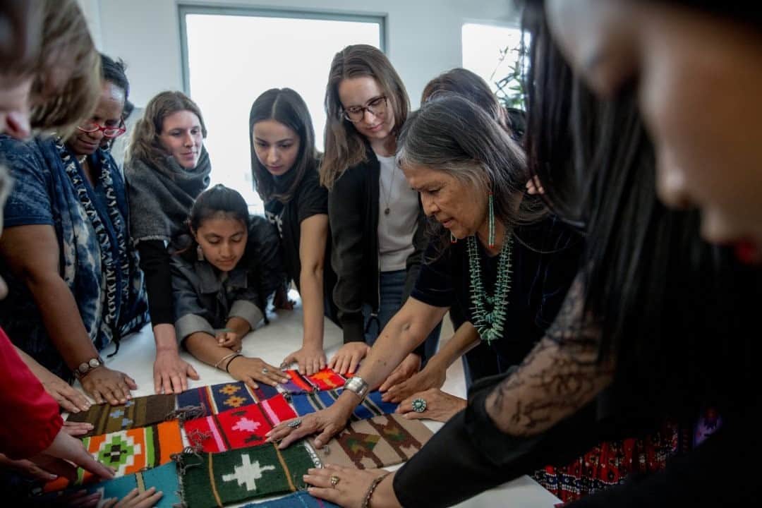 のインスタグラム：「Photo by Daniella Zalcman @dzalcman / Sisters Barbara Teller Ornelas and Lynda Teller Pete led a three-day workshop on traditional Navajo weaving during the inaugural Indigenous Fashion Week Toronto in 2018, teaching students how to make a small rug using traditional processes and patterns. On the third and final day, students finished the workshop with a Navajo prayer from Barbara. While this year's Indigenous Fashion Week Toronto (@ifwtoronto) couldn't proceed because of the pandemic, there will still be four days of online programming, from November 26-29, with online runway presentations and a pop-up marketplace.  Check out Nat Geo's link in bio for more on this story.」