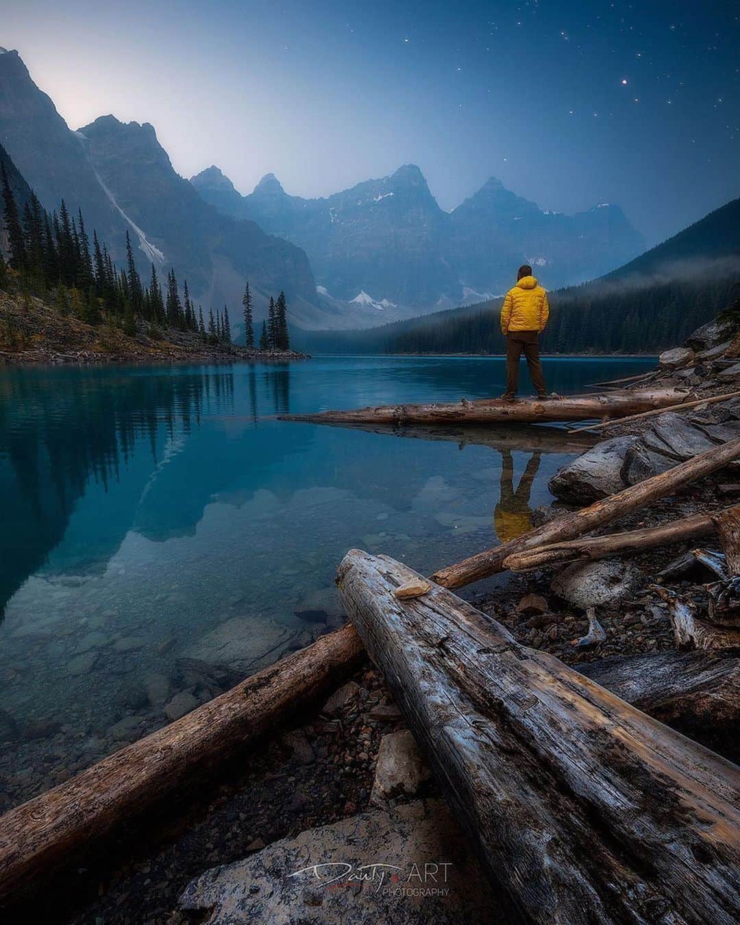 instagoodさんのインスタグラム写真 - (instagoodInstagram)「@dantyartphotography Before Light Just coming back from an awesome trip to one of my favorite place on Earth...the Canadian Rockies! We drove so many kilometers, walked so many hours, slept so little and filled quite a few memory cards with awesome memories captured along the trip! Here’s one from by far the most photographed spot in the Rockies; Moraine Lake. I couldn’t believe how it became that popular over the years. I remember going there over six years ago without even worrying about getting a parking spot there...now if you want to get a sunrise photo of this absolutely awe inspiring location, you’ll need to push your butt out of the bed at 3:45 in the morning and make sure you are there by 5:00 because otherwise you are gonna miss your chance! The parking fills so fast from 5:00 to 6:00...it’s crazy when you consider that the suns goes up at like almost two hours later at this time of the year. I wanted to get my shot so I did get up early. So what do you do when you get there two hours prior to sunrise? You shoot stars! I didn’t get the shot I was looking for because of the smokes coming from the many wildfires in the US but I do have to admit that I really liked the mood added by those said smokes! Here is a selfie shot...oh man, the struggle to run to that spot in less then 10 seconds...the 10 seconds timer was my best friend here as I forgot my wireless remote at home...😂 This image was focus stacked in order to get all details into focus and I did one additional shot with myself standing on that tree. The whole scene is so breathtaking that even after hearing my camera shooting, I just didn’t want to get down that log! It was one truly memorable momrning! Shot on my @canoncanada 5DSr and Canon EF 11-24 f4.0 at 16mm, 1/10 of a second, f11 and ISO100. The starry sky was shot a little before and blended into my final image. Hope you enjoy it! Oh and stay tuned for other stuff from that same trip coming really soon! 😉」11月15日 23時05分 - instagood