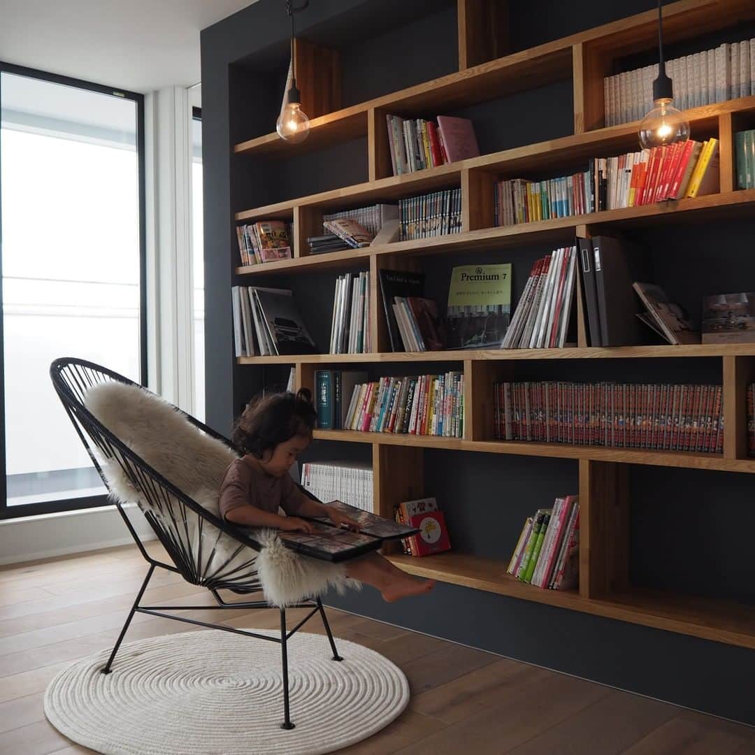 ムクリ［mukuri］さんのインスタグラム写真 - (ムクリ［mukuri］Instagram)「壁一面のオープン収納で、それぞれ趣味の時間を楽しめる場所〜家族みんなが寛げる空間づくり〜  ご夫婦の共通の趣味でもある読書。 本が主役でありながらインテリアの邪魔をしない 本棚スペースについてご紹介しています。  趣味のものや集めているものの収納、 皆さんはどのようにしていますか？  家づくりは、 "家族のコミュニケーションを大切にする" といったブレないコンセプトの下、 趣味の空間もオープンに。  2階の顔にもなっている本棚スペースは、 思い切り趣味の時間を楽しめる場所になっています。  少し奥まった場所にあるピアノ室や 安全面に配慮した階段の仕様など、 こうしておいてよかったなと感じることは、 これから家づくりをする方にも参考になると思いますので、ぜひご覧下さい。  ----------------------------------------------------- ◯本棚 ・サイズ（センチ）：高さ240×横幅283 ・素材：オーク材 ・壁：グレー塗り壁（EP塗り）  ◯ライト ・MUUTO ・アルネヤコブセン/AJライト  ◯本棚の前にある椅子 ・アカプルコチェア  ◯2階建具 ・リクシル：ハイドア ・フローリング：IOCフローリング/カンヌブラウン -----------------------------------------------------  ▶ご紹介した記事 https://mukuri.themedia.jp/posts/7347332 「インテリア」カテゴリーよりご覧いただけます。  #趣味部屋 #書斎 #本棚 #ピアノ #アルネヤコブセン #MUUTO #リクシル #マイホーム #モダンインテリア #キッチン #リビング #ダイニング #吹き抜けのある家 #マイホーム計画 #マイホーム記録 #家づくり #住まい #おうち #新築 #新築一戸建て #注文住宅 #ハウスメーカー #インテリア #シンプルインテリア #北欧インテリア #こどものいる暮らし #暮らし #くらしの編集 #暮らしを楽しむ #ムクリ」11月19日 21時01分 - mukuri_official