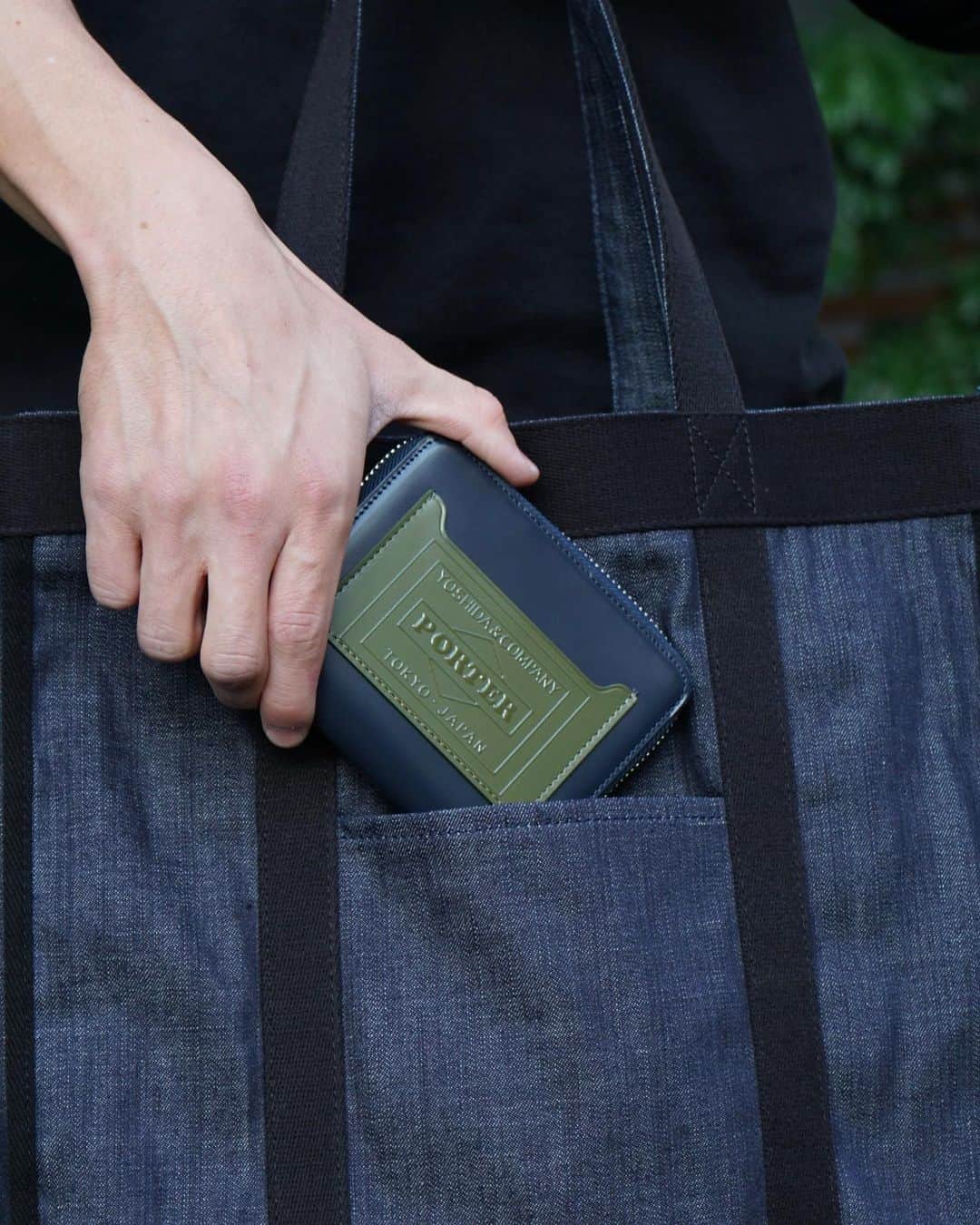 のインスタグラム：「.﻿ SHOP ORIGINAL﻿ PS LEATHER WALLET﻿ CHECKERED FLAG Ver.﻿ ﻿ 独特な光沢感が魅力のガラスレザーを採用したウォレットシリーズ。﻿ ﻿ ICカードポケットと背面にはシリーズ最大の特徴であるチェッカーフラッグ柄を、特殊なインクジェットプリントで立体的に表現しました。﻿ ﻿ ラウンドファスナー仕様の二つ折りウォレットは紙幣や小銭、複数のカードをコンパクトに収納可能です。﻿ ﻿ WALLET﻿ No.384-03077﻿ ￥20,000+tax ﻿ W100/H120mm﻿ ﻿ #yoshidakaban #porter #luggagelabel #madeinjapan #japan #porterstand #shinagawa #tokyo #kyoto #ps #leatherwallet #glass #checkeredflag #wallet #black #orange #navy #olive #exclusive #吉田カバン #ポーター #ポータースタンド #品川 #東京 #京都 #レザーウォレット #ガラスレザー #チェッカーフラッグ #ウォレット」