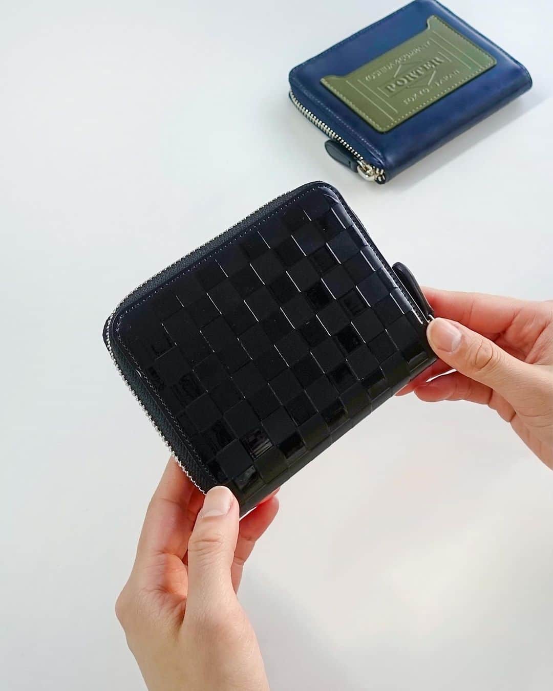 のインスタグラム：「.﻿ SHOP ORIGINAL﻿ PS LEATHER WALLET﻿ CHECKERED FLAG Ver.﻿ ﻿ 独特な光沢感が魅力のガラスレザーを採用したウォレットシリーズ。﻿ ﻿ ICカードポケットと背面にはシリーズ最大の特徴であるチェッカーフラッグ柄を、特殊なインクジェットプリントで立体的に表現しました。﻿ ﻿ ラウンドファスナー仕様の二つ折りウォレットは紙幣や小銭、複数のカードをコンパクトに収納可能です。﻿ ﻿ WALLET﻿ No.384-03077﻿ ￥20,000+tax ﻿ W100/H120mm﻿ ﻿ #yoshidakaban #porter #luggagelabel #madeinjapan #japan #porterstand #shinagawa #tokyo #kyoto #ps #leatherwallet #glass #checkeredflag #wallet #black #orange #navy #olive #exclusive #吉田カバン #ポーター #ポータースタンド #品川 #東京 #京都 #レザーウォレット #ガラスレザー #チェッカーフラッグ #ウォレット」