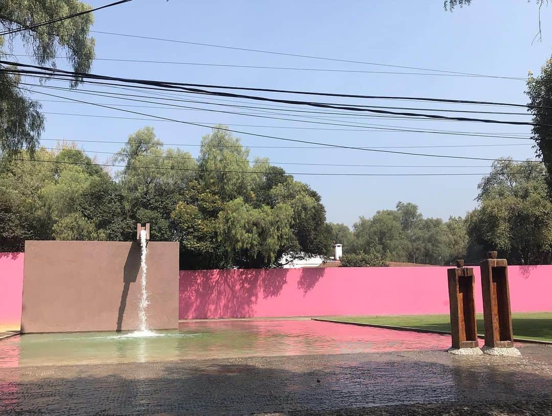 トームさんのインスタグラム写真 - (トームInstagram)「Architecture Classics: Los Clubes - Cuadra San Cristóbal and Fuente de los Amantes / Luis Barragán  At 62 years of age, in 1964, the Mexican architect Luis Barragán began the project of one of his most representative works: the Fuente de los Amantes, located within the Los Clubes neighborhood, in the municipality of Atizapán, State of Mexico. This work is part of a larger intervention, associated within the same project with the Cuadra San Cristóbal (stables) and the Egerstrom House, designed by the architect for a community of horsemen. The set, completed in 1969, became a symbol of his work due to the impeccable use of water, the geometric abstraction of the different planes, and the use of color, recurring elements in his career.  The fountain is one of the spaces for public use within the project. This was supposed to be a living room for riders and their horses, but it was specifically designed as a drinking fountain for animals, not as a decorative fountain. Barragán describes it like this: "I calculated the depth of the pond so that when the horse passed, the water would reach its belly". The rider enters through a side access framed by the great pink wall, then goes down to the pool on the horse, which plunges into the water. All this situation occurs accompanied by the noise of the water, which falls like a waterfall from the aqueduct perfectly supported on another wall of the same material. In this way the water appears calm and moving, changing.  The use of water is characteristic of his work and is influenced by Mexican colonial architecture. But he goes beyond the wells and aqueducts of the haciendas and convents, and designs them as sculptures independent of water, which can maintain their visual and spatial appeal, without the need to be in operation. The Cuadra San Cristóbal, where the stables are arranged, is located 80 meters (approx.) From the source, but they form a single project due to the similar treatment of the elements and the programmatic relationship. The play of pink tones that paradoxically highlights the rather abstract geometry of the walls and the presence of water, link them reading as a single space.」11月20日 6時51分 - tomenyc