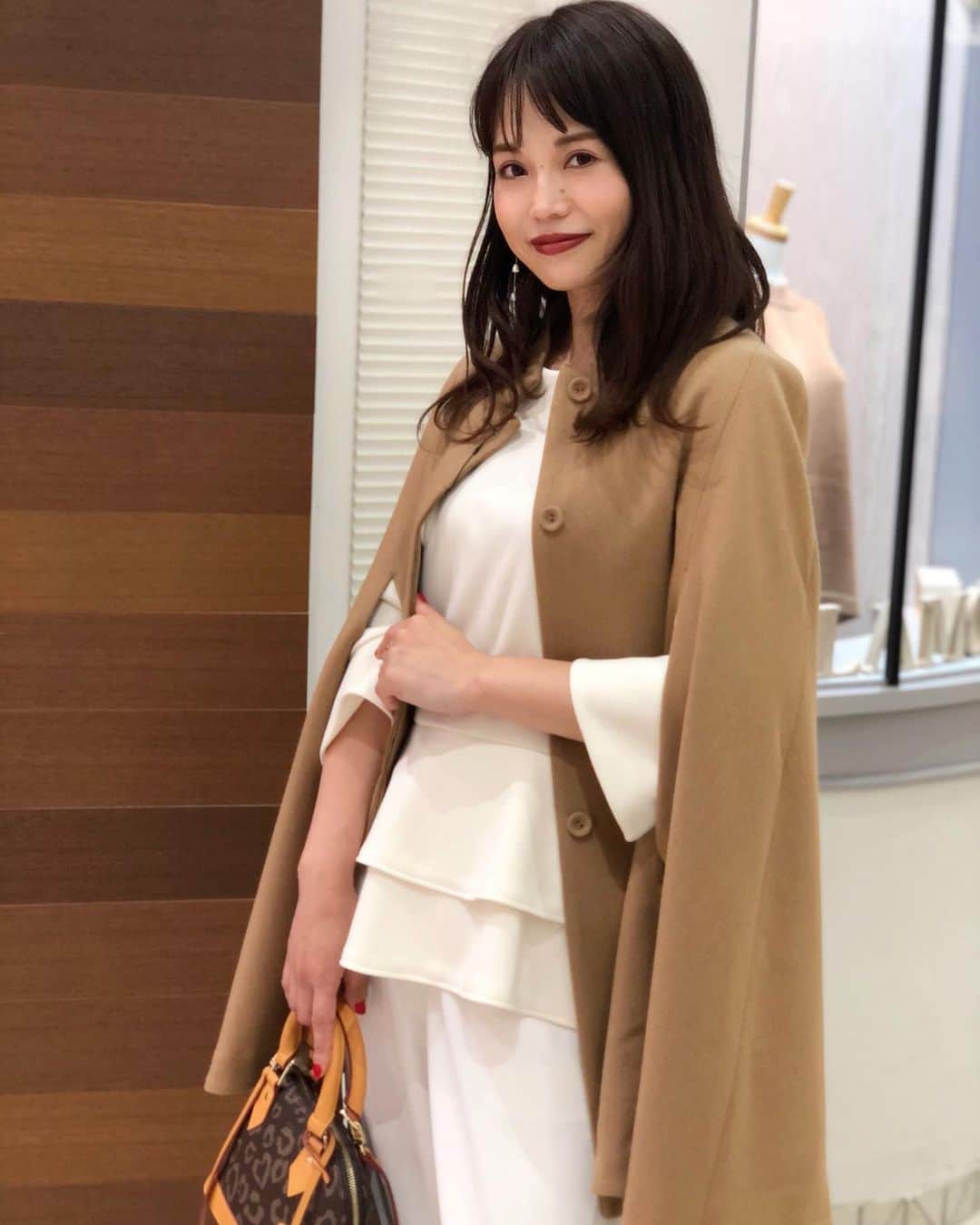 新谷美奈のインスタグラム：「SPECIAL NOVELTY PRESENT🎅🏻🎄💫﻿ ﻿ おはようございます☀﻿ 雨が上がり少し寒くなりましたね！﻿ そろそろコートの出番☃️﻿ ﻿ ジャケット感覚で羽織れるケープコートは﻿ この冬マークしたい一着🧥 袖コンシャス、オーバーサイズが主流の今 中に何を着てても羽織れるところが嬉しい！ そして何より軽い！﻿  ベージュはワントーンでまとめて品よく。﻿ ﻿ Nina mew﻿ coat ¥36,000+tax﻿ tops ¥19,000+tax﻿ pants ¥18,000+tax﻿ bag ¥18,000+tax﻿ ______________________________________﻿ ﻿ ✔︎11/19(木)よりGATHER全店にて﻿ Nina mewの商品を税込4万円以上お買い上げの方に﻿ ロゴトートバッグをプレゼント！﻿ (なくなり次第終了となります)﻿ 今回は超数量限定です😳💗﻿ ﻿ ✔︎11/19(木)〜23(月)まで﻿ 連続ゆめポイント5倍！﻿ ﻿ 皆様のご来店心よりお待ちしております！﻿ ﻿ @ninamew_official#Ninamew#ニーナミュウ#ゆめタウン#ゆめタウン佐賀#セレクトショップ#selectshop」