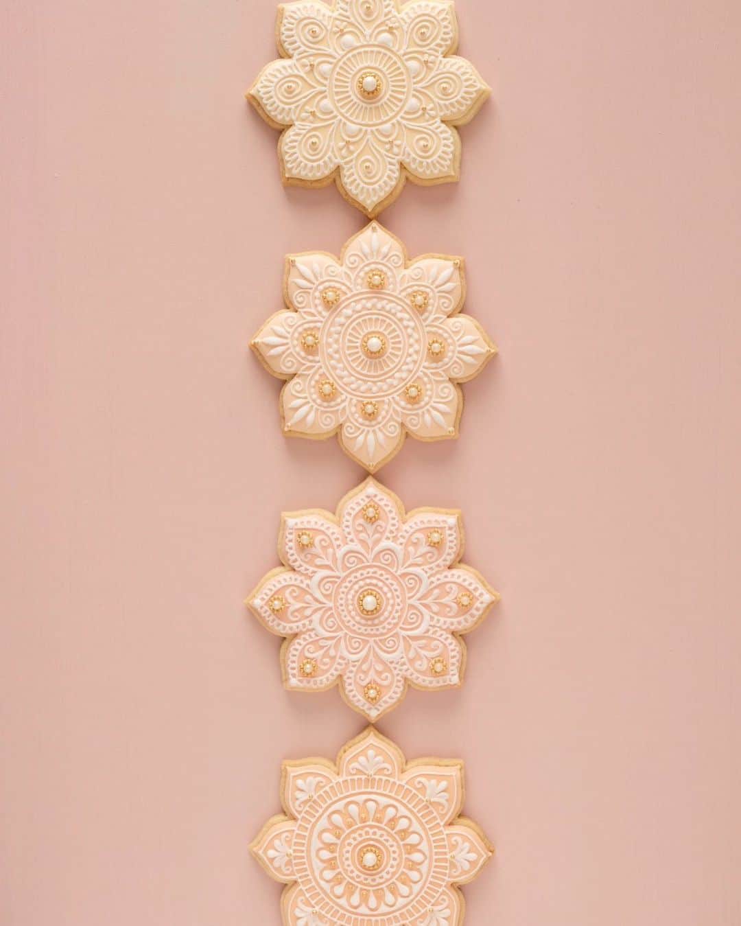 KUNIKAのインスタグラム：「All hand painted mehendi flower cookies in sand beach color ❃  ロンドンで少しずつクッキーを作り始めてわかったこと...  日照時間が少ない(日没16時) ↓ すぐ部屋が暗くなる、部屋の明かりが小さい(生活する分には十分だけど) ↓ 豆電球のオレンジの光なので、微妙な色の違いが分かりにくくて判断が難しい(一大事😨)  オレンジの豆電球は好きだから、白い光のスタンドライト買おうかな。 ちょっとずつ整えていこう〜  #artofkunika」