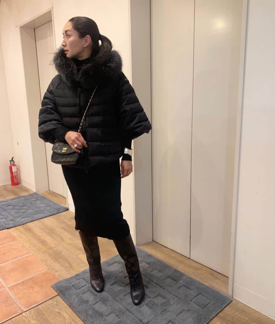 亀恭子のインスタグラム：「@tatras_official  ポンチョ風のダウンジャケット。  ここ数年、カジュアルなダウンを着ていたので ファーが付いてるタイプは久しぶり。  ファーもボディもブラック、 シルエットはオーバーAライン。 なんともクールでエレガント❤︎  ちなみにかなり久しぶりにネイルサロンに行きました。 ロイヤルミルクティーみたいなベージュ。  black, silver, beige の日。  someday's… #fashion #ootd #kkstyle #tokyo #kamescloset #jacket #tatras #knit #epocatheshop #skirt #bluebirdboulevard #bag #chanel #shoes #hermes #winter #december」