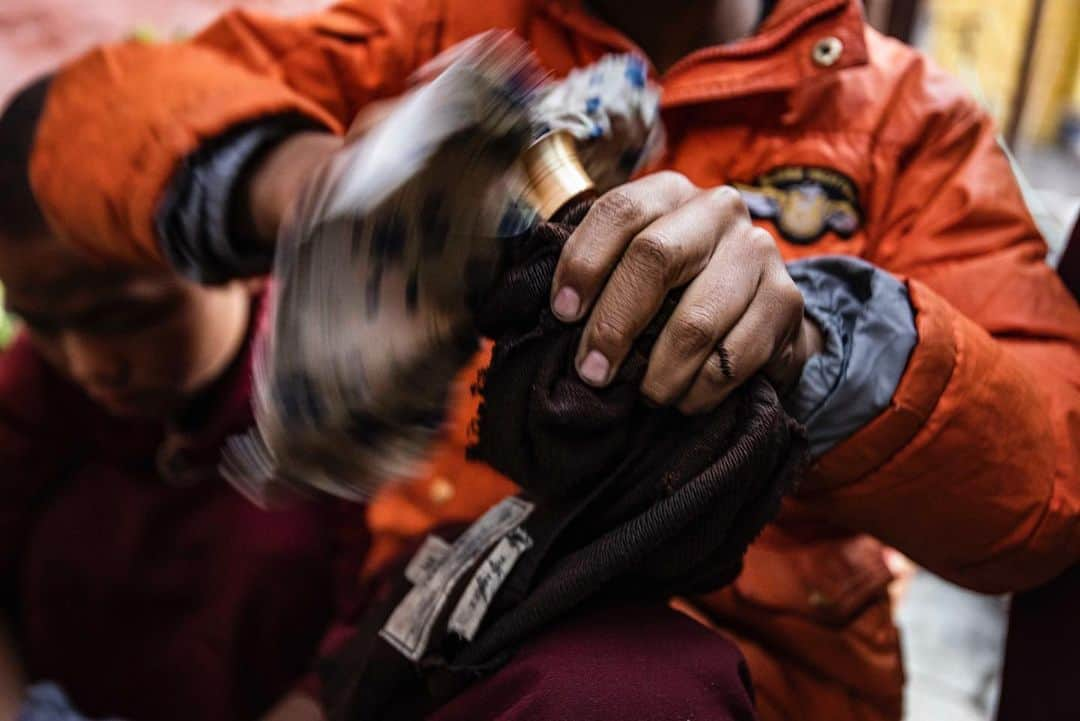 Cory Richardsのインスタグラム：「High up in the Himalaya, yak butter burns day and night in Tibetan temples. These butter lamps can be found in every Tibetan Buddhist temple as an integral part of each religious practice and ceremony. Pictured here is a young boy cleaning a recently used butter lamp in preparation for the evening’s mediation. Shot #onassignment for @natgeo」