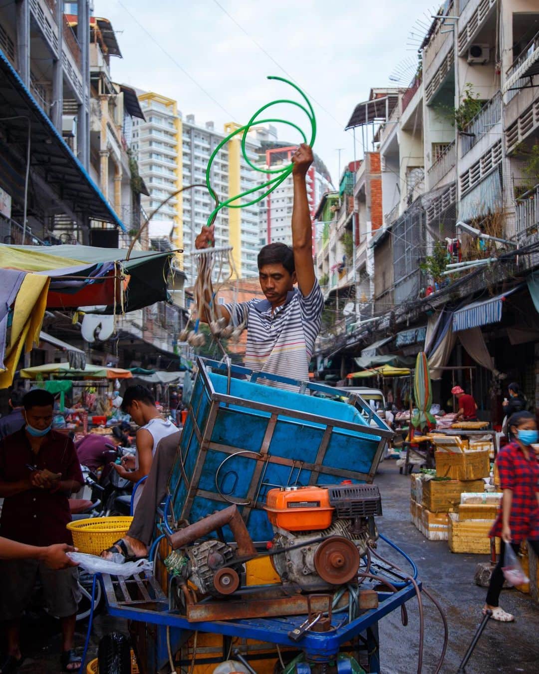 Shunsuke Miyatakeのインスタグラム：「A man quickly taking out oxygen tubes from a container to keep fish fresh at a roadside market, Phnom Penh, Cambodia」
