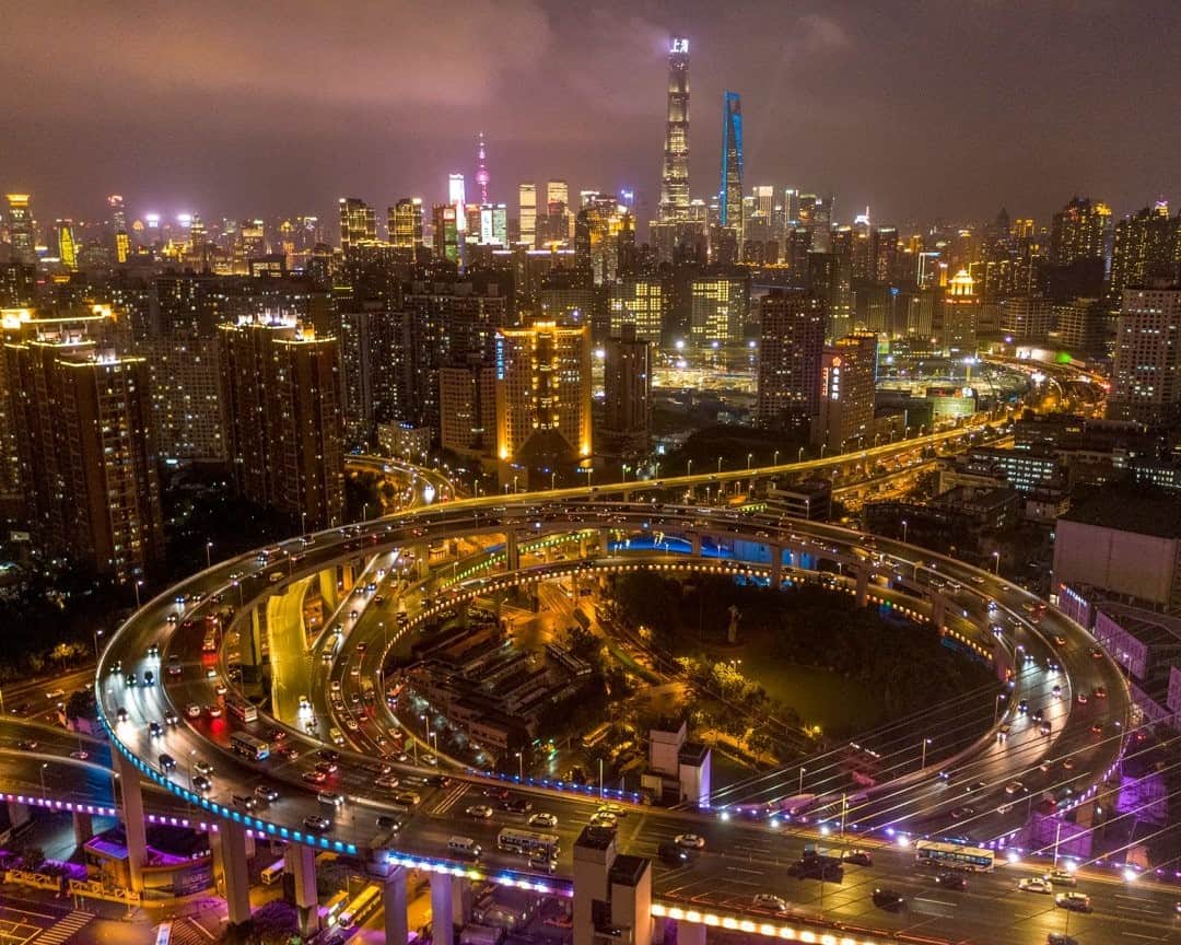 National Geographic Travelさんのインスタグラム写真 - (National Geographic TravelInstagram)「Photo by George Steinmetz @geosteinmetz / A rare, relatively quiet evening commute on the Nanpu Bridge and spiral interchange in Shanghai. As China’s middle class has exploded, so have car ownership and vehicle traffic. In 2009 the country had 62 million registered vehicles. By 2017 the tally topped an unimaginable 300 million. Unrelenting expansion of demand for personal transport has lured American manufacturers, including Ford, which in 2017 began selling its Ford F-150 pickup truck there. To cut congestion, smog, and climate-warming emissions, China is pursuing a host of policies, with a big push to mass transit as well as electric, autonomous, and shared vehicles. But the challenge of getting to and from hundreds of cities will remain enormous.  To see more of our world from above, follow @geosteinmetz.」12月16日 0時37分 - natgeotravel