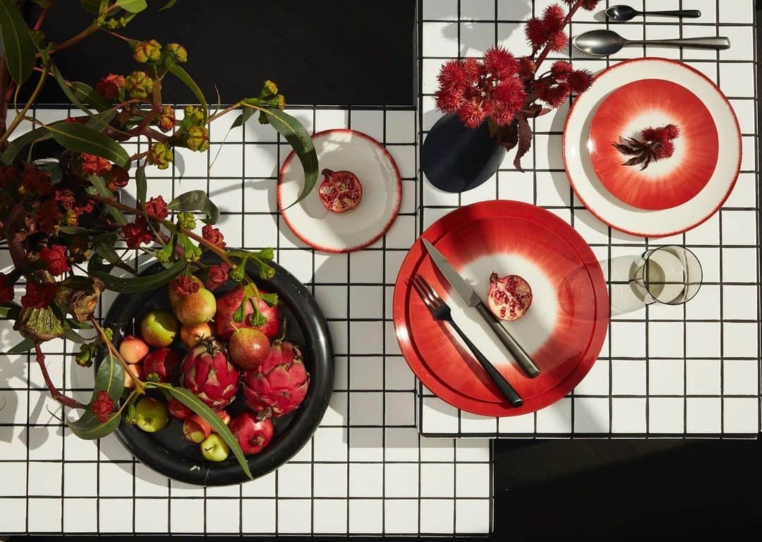 ケリーウェアスラーのインスタグラム：「HOLIDAY FÊTE. You might think a gridded black and white surface would steal most visual shows, but it perfectly offsets this red-themed tablescape – complete with scarlet plates, sanguine foliage and ruby-colored foods. Dark plates, vases and flatware tie together the vivid scheme, forming a festive dining experience fit for a modernist. XK」