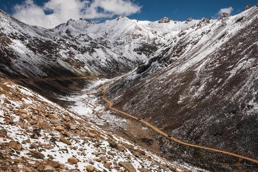 Michael Yamashitaさんのインスタグラム写真 - (Michael YamashitaInstagram)「Long and winding road: Mountain passes like these in Kham (eastern Tibet) offer some of the most spectacular vantage points for photography, but sadly, they are disappearing as China burrows under the ranges with tunnels to make way for highways. Though the tunnels decrease travel time and make the far reaches of Tibet more accessible, they now make it harder than ever to reach these passes. In the past, I would look forward to driving over these sometimes treacherous lofty passes by four-wheel drive to take advantage of the panoramic picture possibilities from the top.  Now the only way over is by foot, not an easy feat when hiking over mountains at altitudes as high as 15,000 feet.   From the new edition of my book, SHANGRI-LA [ALONG THE TEA ROAD TO LHASA]. Available where books are sold.  #ShangriLa #teahorseroad #tibet #newbookalert #Yunnan #mountainpass」12月16日 4時38分 - yamashitaphoto