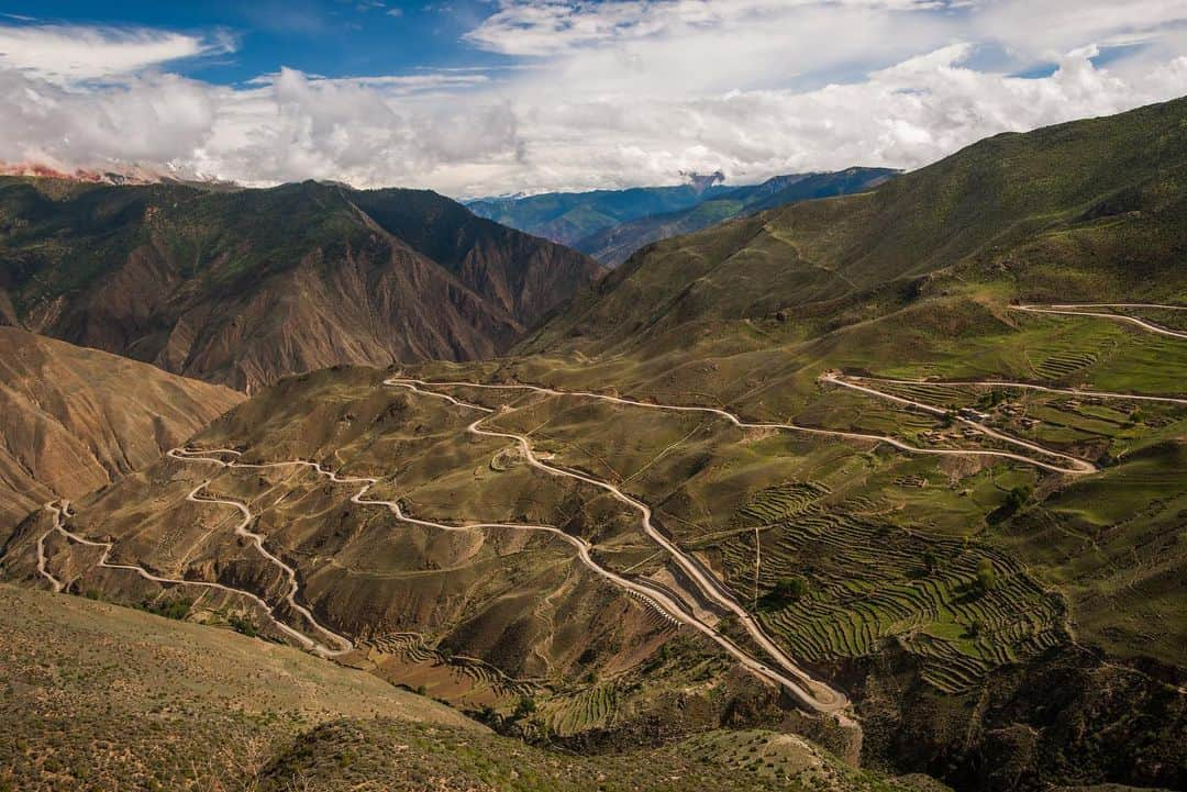 Michael Yamashitaさんのインスタグラム写真 - (Michael YamashitaInstagram)「Long and winding road: Mountain passes like these in Kham (eastern Tibet) offer some of the most spectacular vantage points for photography, but sadly, they are disappearing as China burrows under the ranges with tunnels to make way for highways. Though the tunnels decrease travel time and make the far reaches of Tibet more accessible, they now make it harder than ever to reach these passes. In the past, I would look forward to driving over these sometimes treacherous lofty passes by four-wheel drive to take advantage of the panoramic picture possibilities from the top.  Now the only way over is by foot, not an easy feat when hiking over mountains at altitudes as high as 15,000 feet.   From the new edition of my book, SHANGRI-LA [ALONG THE TEA ROAD TO LHASA]. Available where books are sold.  #ShangriLa #teahorseroad #tibet #newbookalert #Yunnan #mountainpass」12月16日 4時38分 - yamashitaphoto