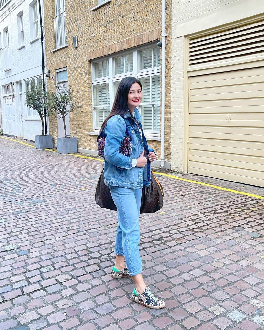 のインスタグラム：「Double denim travel outfit. Looks like I’m not travelling anywhere for a bit but why not remember. Still works for an everyday look too. I just wore this to carry my clothes to shoot to @hotelkensington. This weekend bag is so old, the leather broke and I had @therestory_ repair it. #peonylimstyle #doubledenim #traveloutfit」
