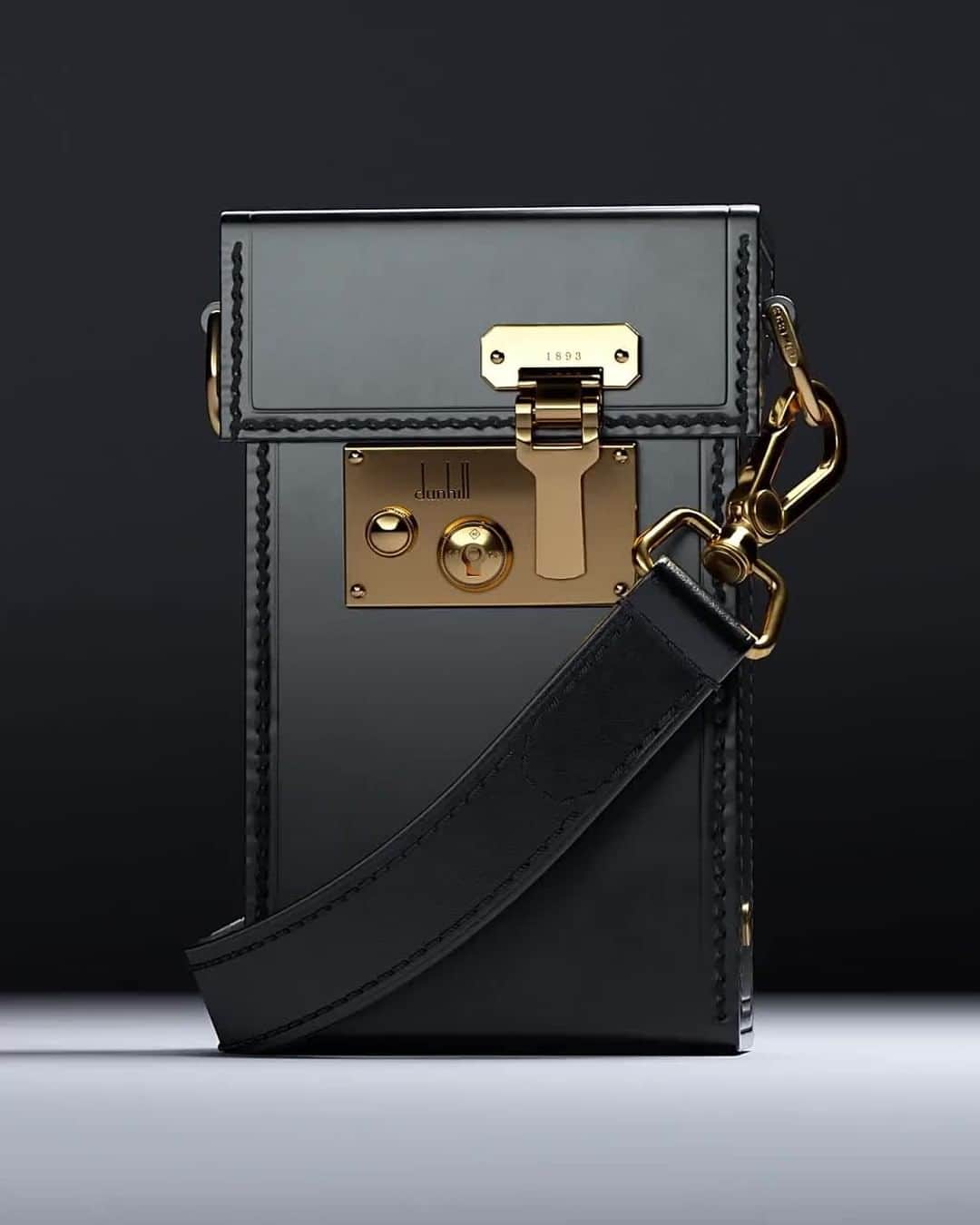 のインスタグラム：「THE LOCK BAG⁠ A NEW HOUSE ICON⁠ #dunhillAW20⁠ ⁠ The Lock bag is inspired by classic attaché cases from the dunhill archive.⁠ Available now in our Instagram shop.⁠ ⁠ Constructed from luxurious box calfskin in black, this beautiful leather ages well over time allowing each bag to develop its own individual patina and character. Each style features a polished brass lock also drawn from our archive; reimagined with the founding year of the House and engraved Longtail logo. ⁠ ⁠ #dunhillLOCKBAG⁠ ⁠ DUNHILL.COM」