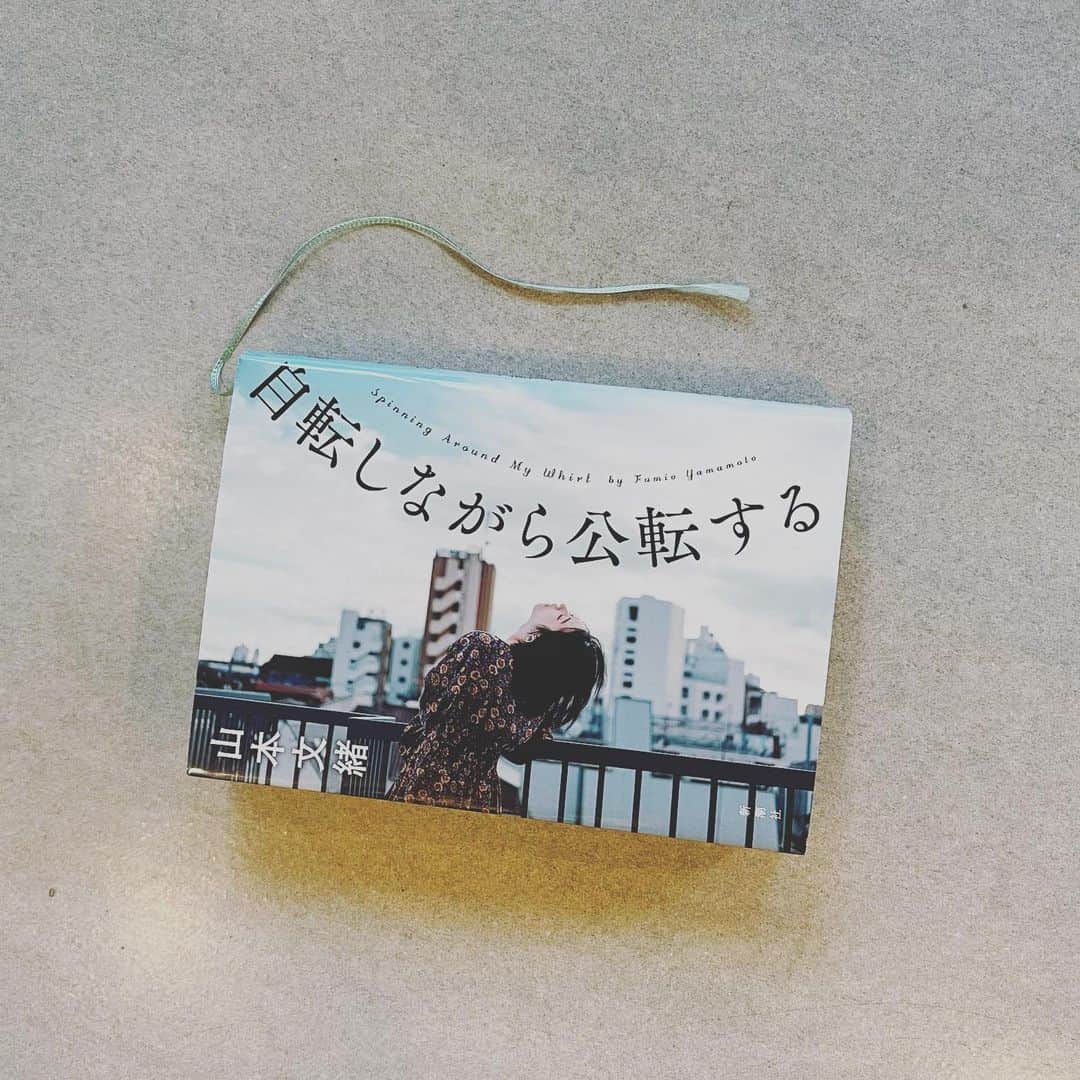 のインスタグラム：「2020年の今が全部詰まっているお話だった。 私は以前から山本文緒さんの小説が大好きで（多分初めて読んだのは「ブラック・ティ」かな？）その巧みな構成力と癖になる毒味に夢中でいつも一気読みしてしまう。 ほとんどのお話を読んでいるので新刊もとても楽しみにしていたのだけど、いい意味で山本さんらしくないストレートな恋愛小説で、でもそこに今私たちが抱えてる問題が、あらゆる世代、性別にわたってきめ細やかに余すところなく描かれていてその筆力に唸ってしまった…。しかも主人公の都含め全てがフレッシュで生き生きとして、今そこにいる感じがする。7年待った甲斐があるお話だった…。 一見ベーシックなテーマなんだけどベテランの底力とそこに妥協しない新たな挑戦、緻密な推敲を感じて、同じお話を作る者の端くれとしてもとても刺激されました。 特に私が好きだったのは都の相手役貫一のキャラ。これは惚れるわ！！めっちゃ今時のひょろっとして前髪で目が見えない、なに考えてるかわからない男の子をビジュアライズして読んでた！もー、途中貫一目線でハラハラページをめくってしまったよ…。 プロローグとエピローグは書籍化で付け足されたらしいのだけど、ミステリ小説家としての山本文緒好きとしては私はアリでした。すっかり掌で転がされて良い気分で本を閉じれたし、都の最後のセリフに全てが集約されているよね…。 2020年最後に読むのに本当におすすめの一冊です！ #自転しながら公転する #山本文緒　さん #あさイチも楽しかった」
