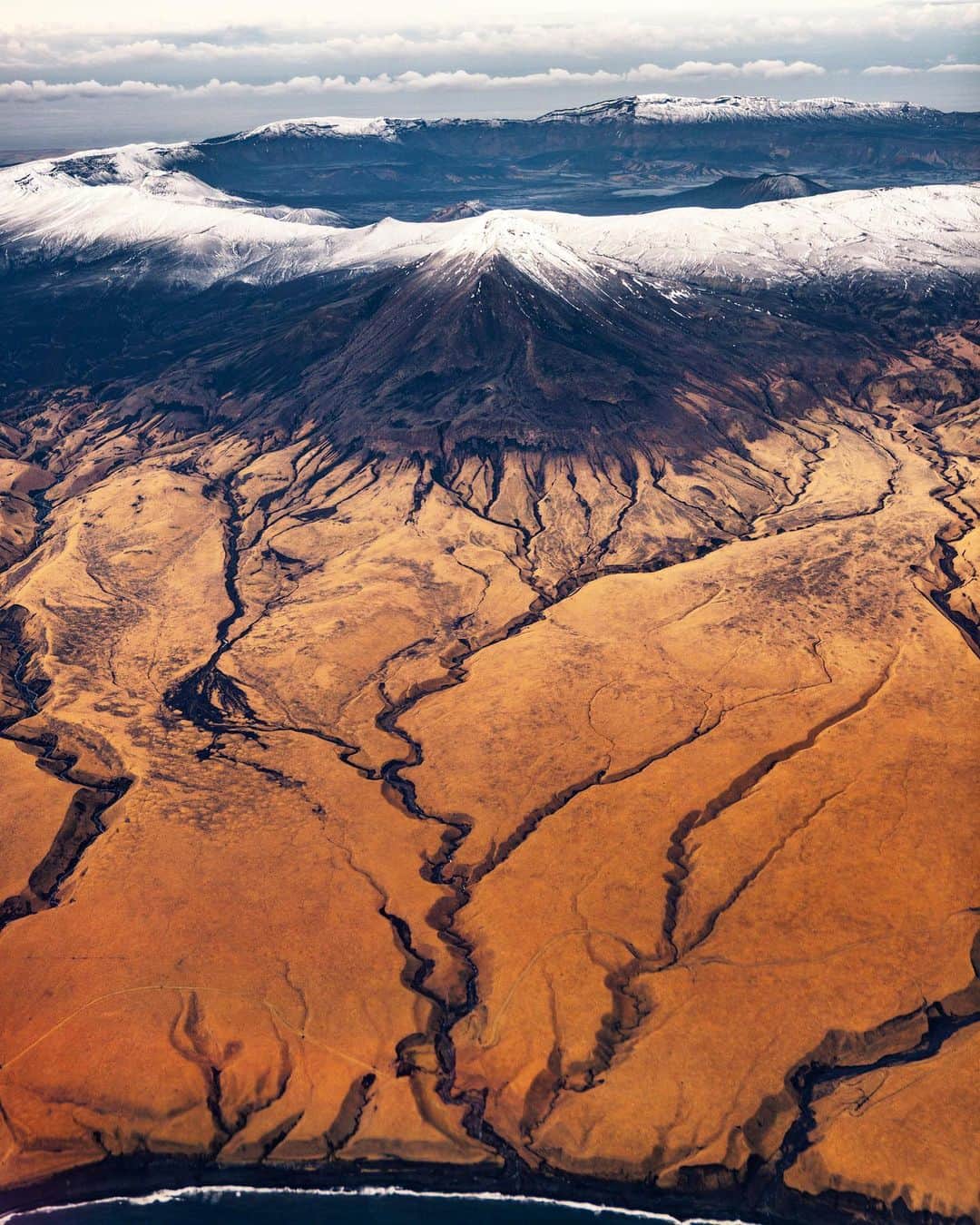 クリス・バーカードのインスタグラム：「A sneak peak into Mount Okmok caldera. At 5.8 miles across this was at one time one of the largest Volcanos in the ring of fire. Now it sits as the largest caldera where leftover tendrils of lava carved a path for water to make its way to the ocean.」