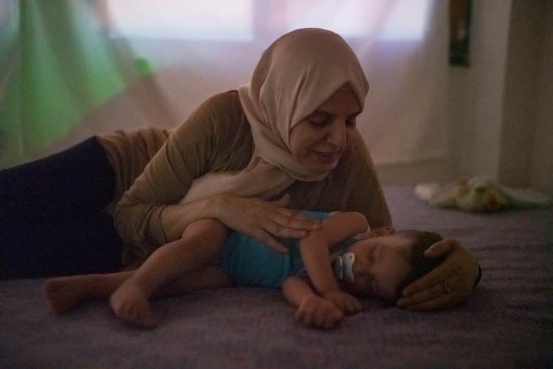 のインスタグラム：「Photo by @hannahreyesmorales / Over the last year, we’ve been exploring what might be the very first love songs that we hear: lullabies. We wanted to find out what bedtime looked and sounded like for families around the world. We carry lullabies across borders and create new ones along the way. Mona, a Syrian refugee living in Turkey, tells us that for her, the lullaby is a "window into the caregivers’ soul." Here she’s seen with her first grandchild, Zaid, in their home in Hatay. In 2013 Mona fled Syria and joined her son in Turkey, where Zaid was born.   “As Arabs, we have a proverb: No one is more worthy than your child but your grandchild,” she says. She sings songs to him in the hope that he might know a piece of Syria where his family is from.   Read more on lullabies in the December issue of @natgeo. #livinglullabies #Mongolia @insidenatgeo @timstrust  Check out Nat Geo's link in bio for more on this story.」