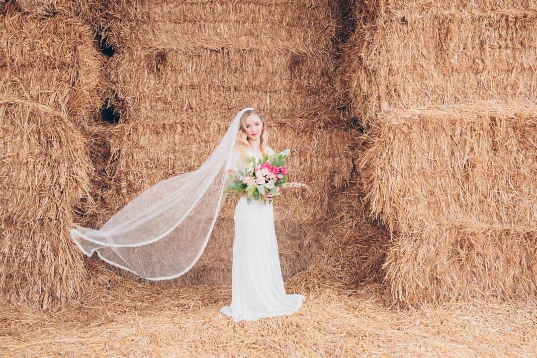 ミナのインスタグラム：「I can almost smell the hay looking at these pictures! 😍⁠ ⁠ Converted barn is quite a usual choice of reception venue for indiebrides. Here's some more inspiration from a recent shoot at @manorfarmbarn1 featuring our Ariel dress and Cassie veil. Link in bio.⁠ ⁠ Organiser: @luna_rose_events ⁠ Photographer: @gemmarandallweddings ⁠ Florist: @flourish.uk ⁠ Cake: @iced.delights.cakes ⁠ Stationery: @tiggityboodesign ⁠ Hair and makeup: @debbiemac_mua ⁠ Film: @luke_houghton_films ⁠ Film: @maxinefurnessfilms ⁠ Welcome sign: @_botanicalbloom ⁠ Denim jacket: @gamusinodesigns ⁠ Garter: @hayze.boutique ⁠ ⁠」