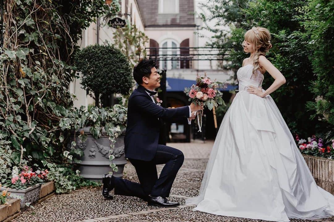 のインスタグラム：「ウェディングフォト💓続き✨  これは特別お気に入り❤️ 夫が撮影中カメラマンさんに 「どうしてもやりたいカットがあって、、いいですか？！」 って言って膝ついてこれ🤣💕  なぜか思わず手を腰にする私。w  darling最高❤️🧡❤️  #ウェディングフォト　#ウェディングドレス　#magnoliawhite #プロポーズ」