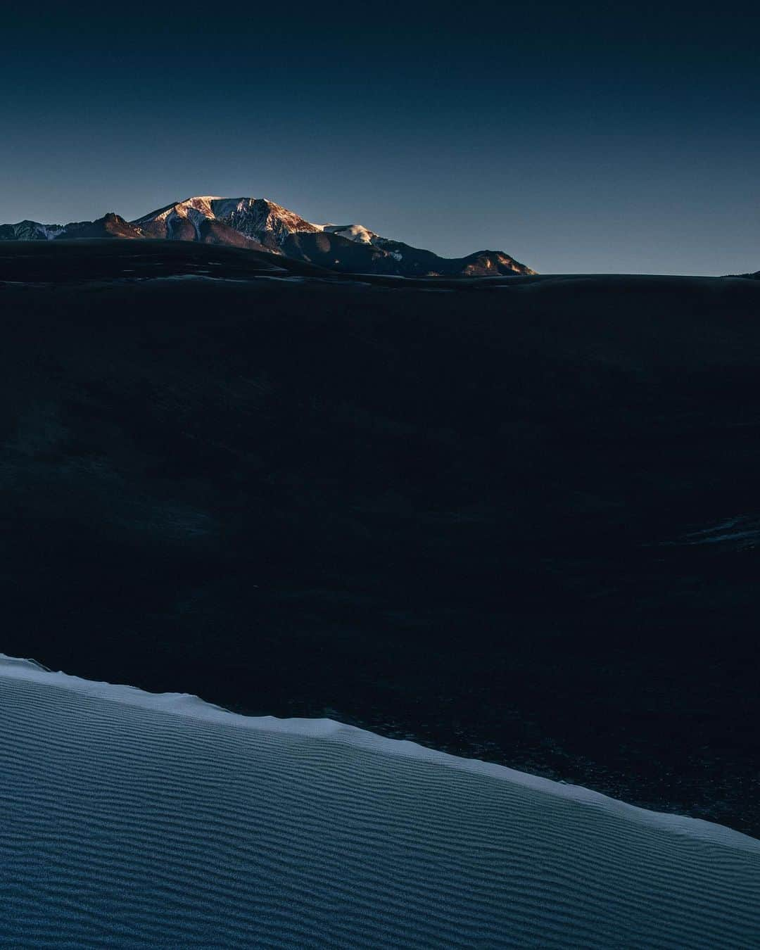 National Geographic Travelさんのインスタグラム写真 - (National Geographic TravelInstagram)「Photo by @joshuacogan / Trying to catch sunrise at Great Sand Dunes National Park can be a challenge. Getting up onto the dunes themselves is no easy task, as every step equals two on a normal ascent because the sand gives no solid surface. On this frosty early morning, I was rewarded with a few nice surprises: the cresting sun on the snowcapped peaks in the background and the frost-covered dunes in the foreground creating beautiful glistening reflections.  For more images of our incredible public lands and journeys through the world, follow me @joshuacogan. #ourpubliclands」11月28日 1時35分 - natgeotravel