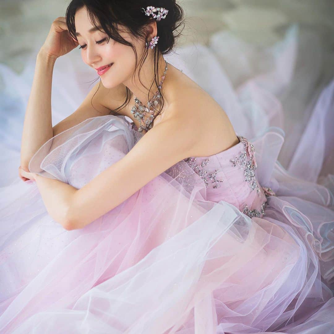 fino_wedding【フィーノ公式】さんのインスタグラム写真 - (fino_wedding【フィーノ公式】Instagram)「AK-10805 8色のチュールを接ぎ合わせたスカートと挟み込まれたフラウンスが重なり合い、ニュアンスのあるカラーグラデーションを表現しています。 精緻に作られた２種類のインド加工モチーフをあしらった身頃は鮮やかなスカートとは対照的に重厚感のある雰囲気で、オートクチュールらしい高級感を打ち出しています。 インド加工モチーフをドレスに使用する事で贅沢な輝きと重厚感を表現。あえてボディをカシュクールデザインにすることでバックラインもすっきりとしたシルエットに。 トレーンのように流れるリボンがエレガントでキュート！ 360度どこから見ても美しい桂由美のカラードレス  @fino_wedding  . . ---------------------------  ♡公式ホームページ https://www.fino.wedding/ . ☎️：054-280-2525 静岡：@fino_shizuoka 富士：@fino_fuji 沼津：@fino_numazu 和装：@finohanayome  ---------------------------  #桂由美 #カラードレス  #おすすめドレス  #カラードレス試着  #ピンク  #パープル  #グラデーションカラー  #キラキラ  #グリッターチュール  #インドビジュー  #おしゃれ花嫁  #エレガント  #2021春婚  #2021夏婚  #2021秋婚  #2021冬婚  #静岡花嫁  #フォトウェディング  #likeforlikes  #wedding  #weddingdress  #weddinghair  #colordress  #coctaildress  #色違いあります  #ゴールドブラウン  #試着してね  #バックリボン」11月29日 21時23分 - fino_wedding
