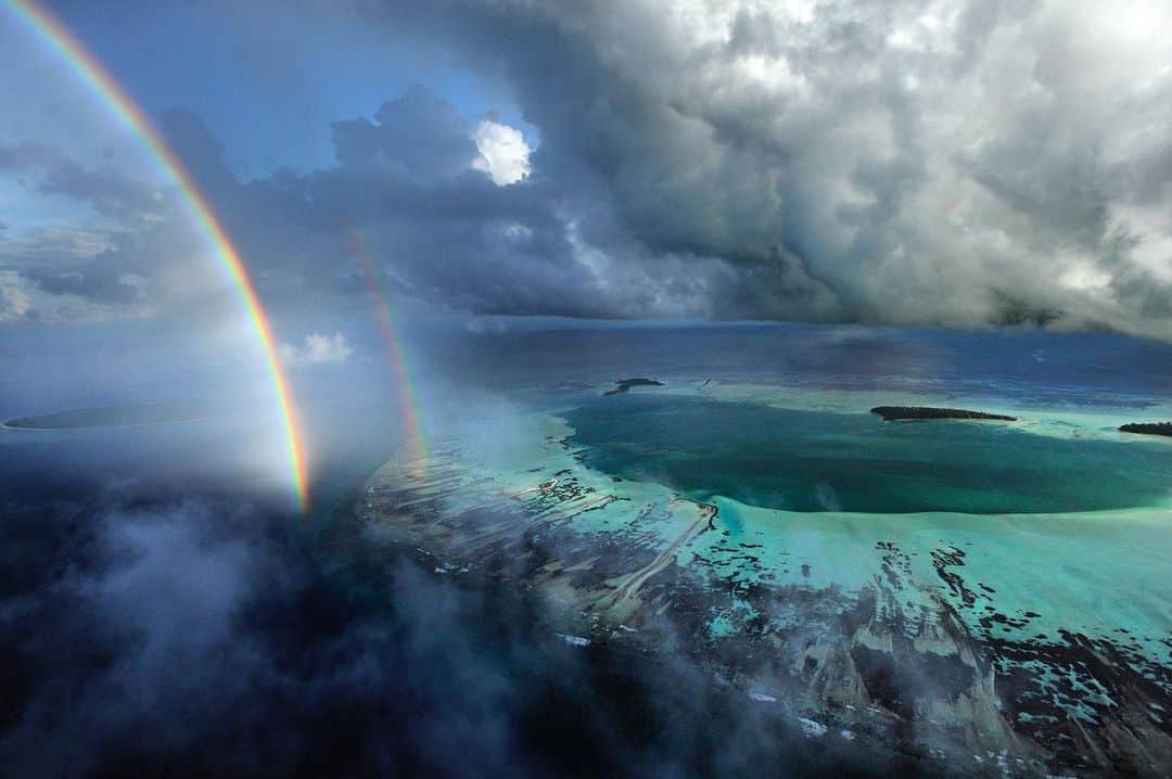 Thomas Peschakのインスタグラム：「I remember this flight like it was yesterday. Just as fuel was running low a second rainbow appeared in the channel between D’Arros Island and St. Joseph atoll. I only got one more pass to photograph before we had to land, but it was just enough time to capture this scene.  In March 2020 the waters around these two islands were declared the Seychelles newest marine protected area. The @saveourseasfoundation operates a research station on D’Arros and conducts science critical to the conservation of sharks, manta rays, turtles, reef fish and corals.」